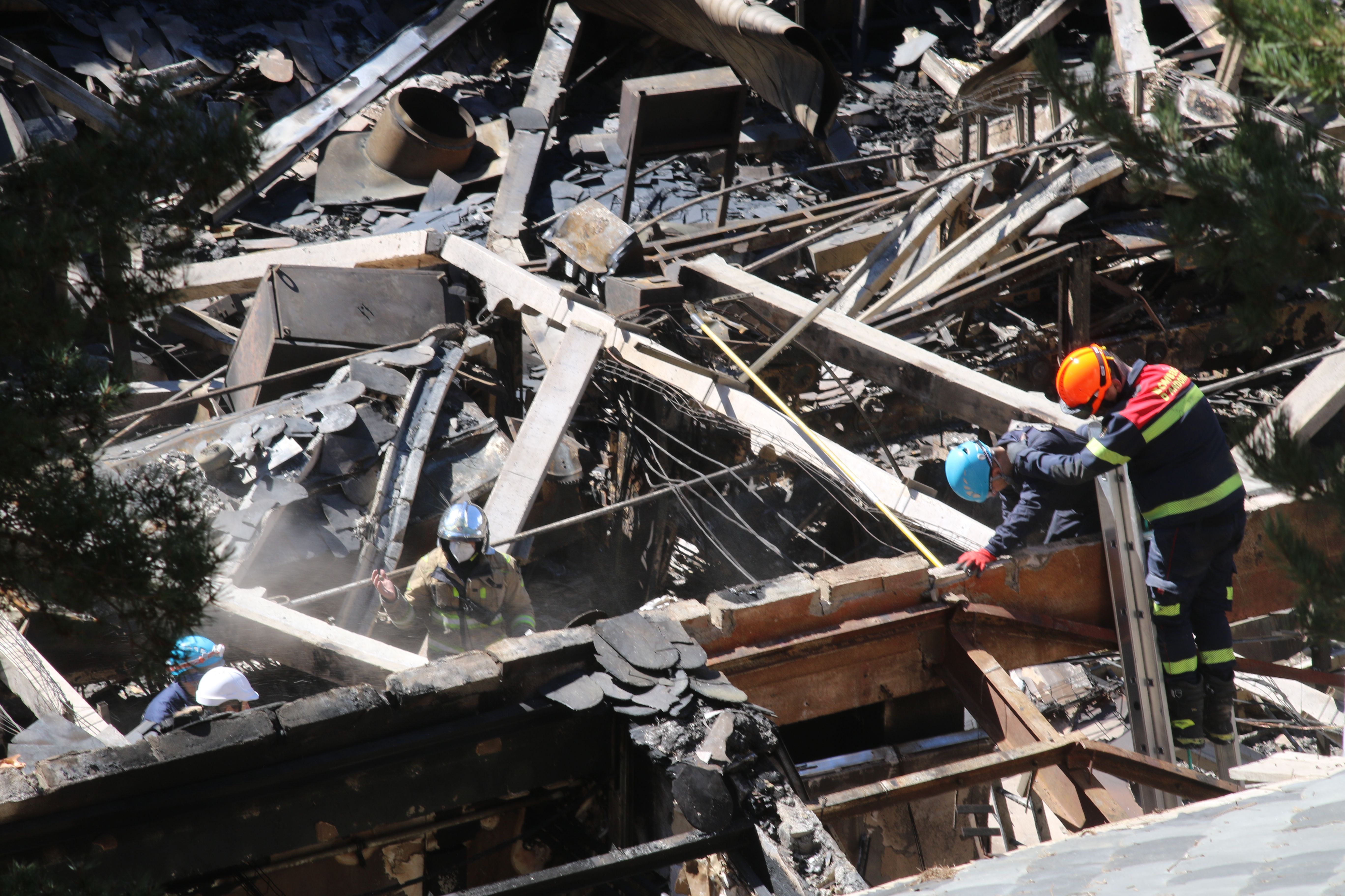 Bombers i policies inspeccionant la fàbrica derruïda. Bombers i policies inspeccionant la fàbrica derruïda.