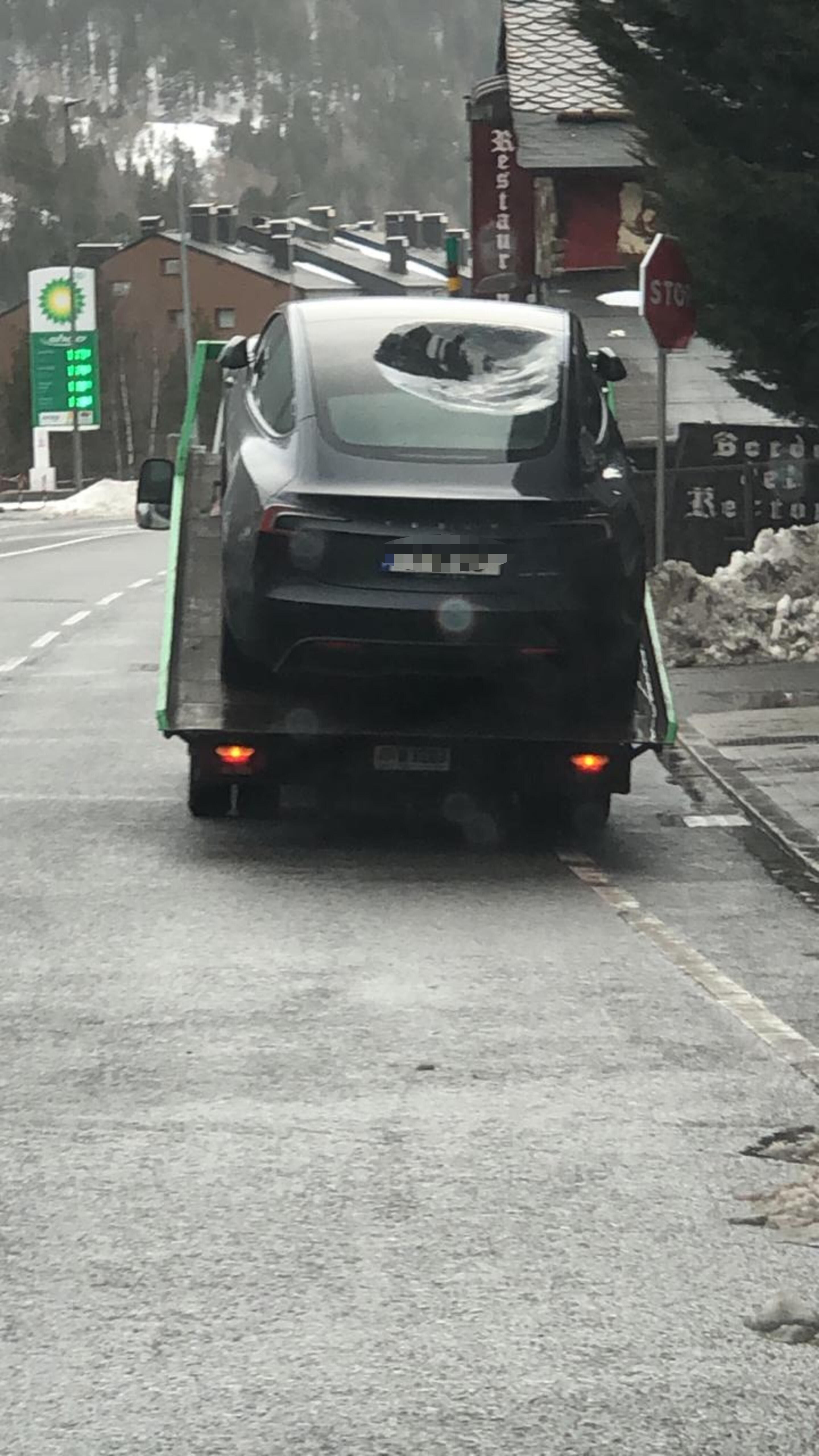 El Tesla carregat a la grua de plataforma.