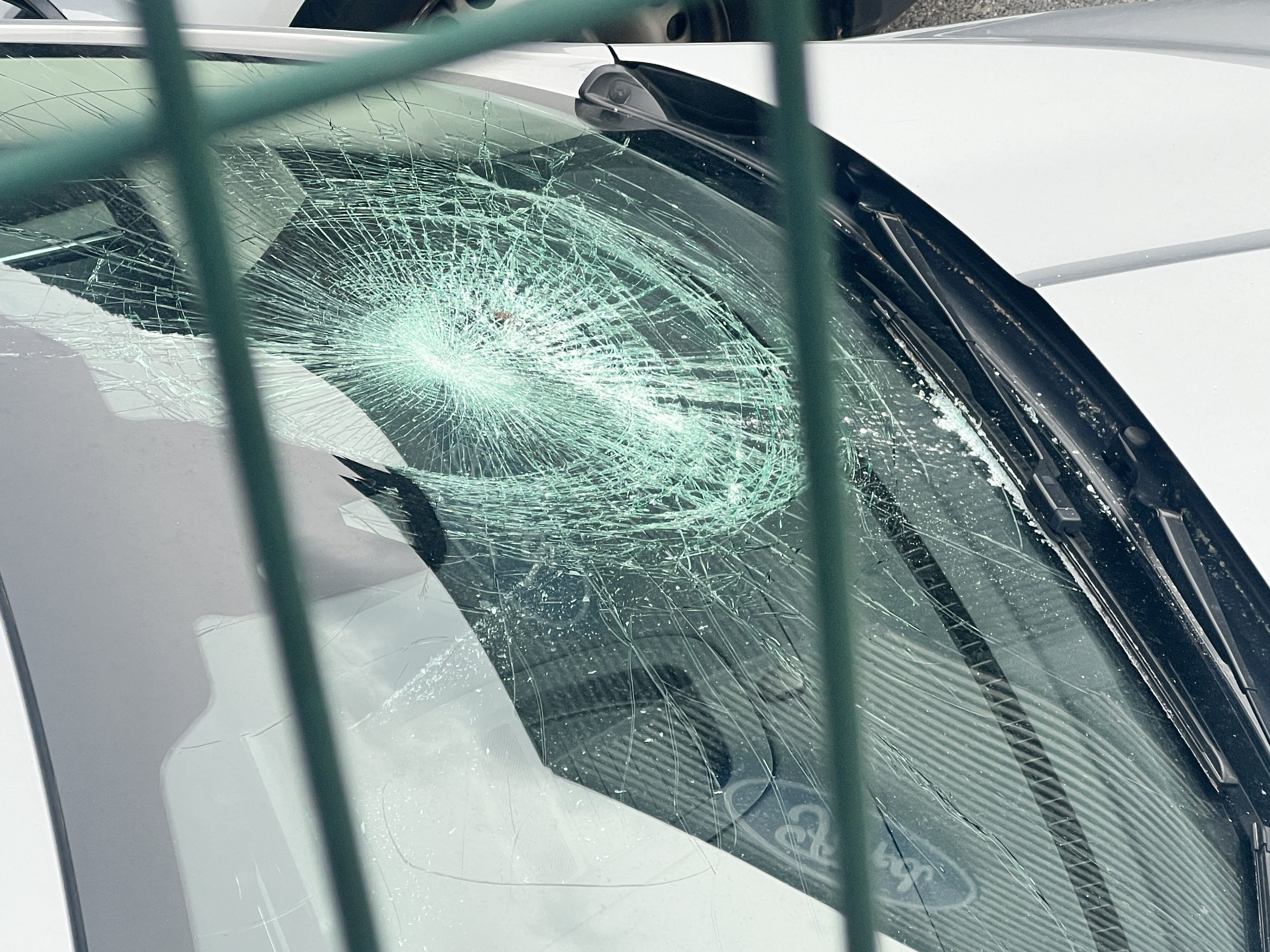 El parabrisa d'un dels cotxes estacionats a l'aire lliure però dins el recinte automobilístic i que ha resultat danyat. El parabrisa d'un dels cotxes estacionats a l'aire lliure però dins el recinte automobilístic i que ha resultat danyat.