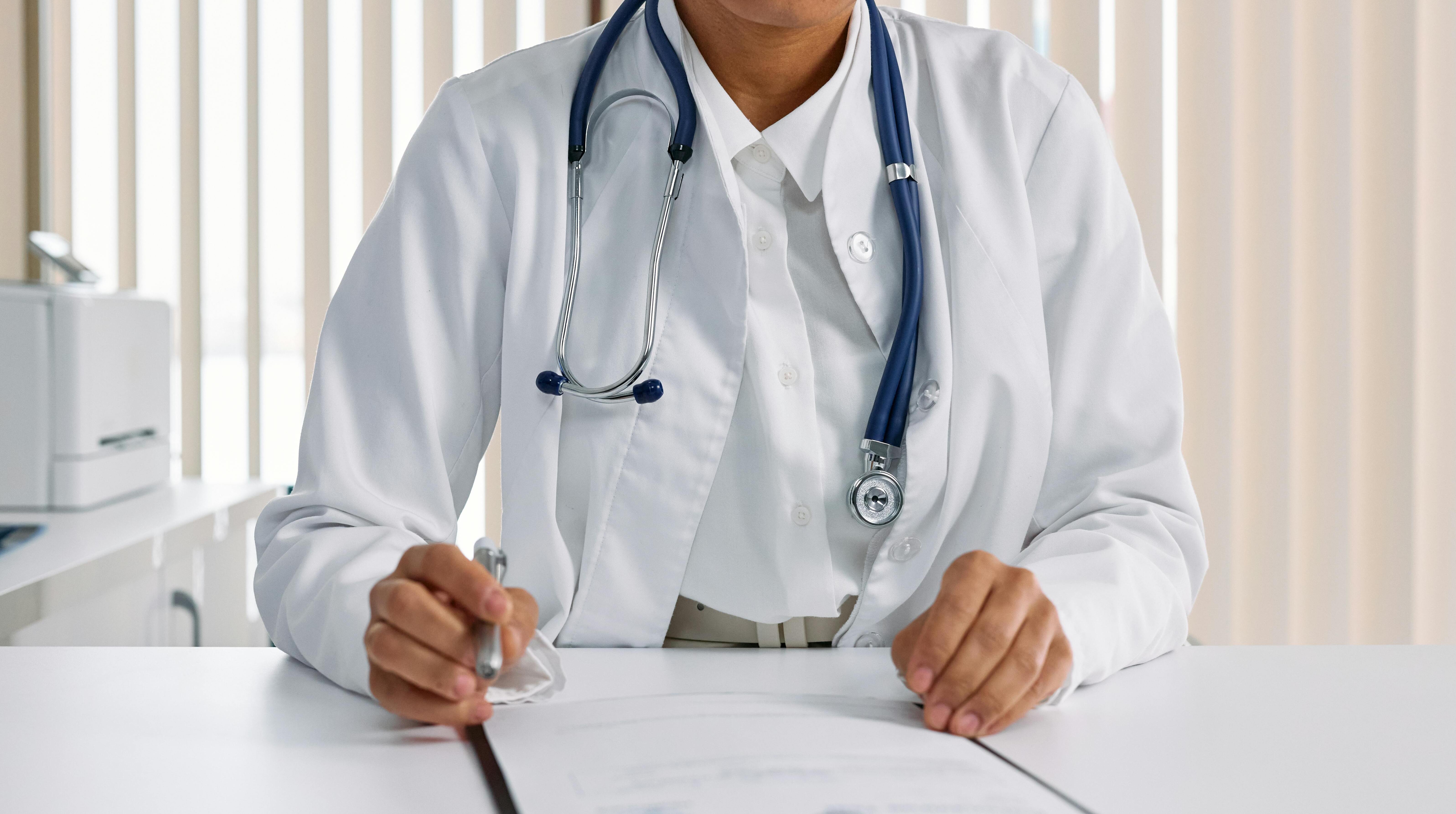 Una metgessa en una consulta repassant els resultats d'una prova feta a un pacient.