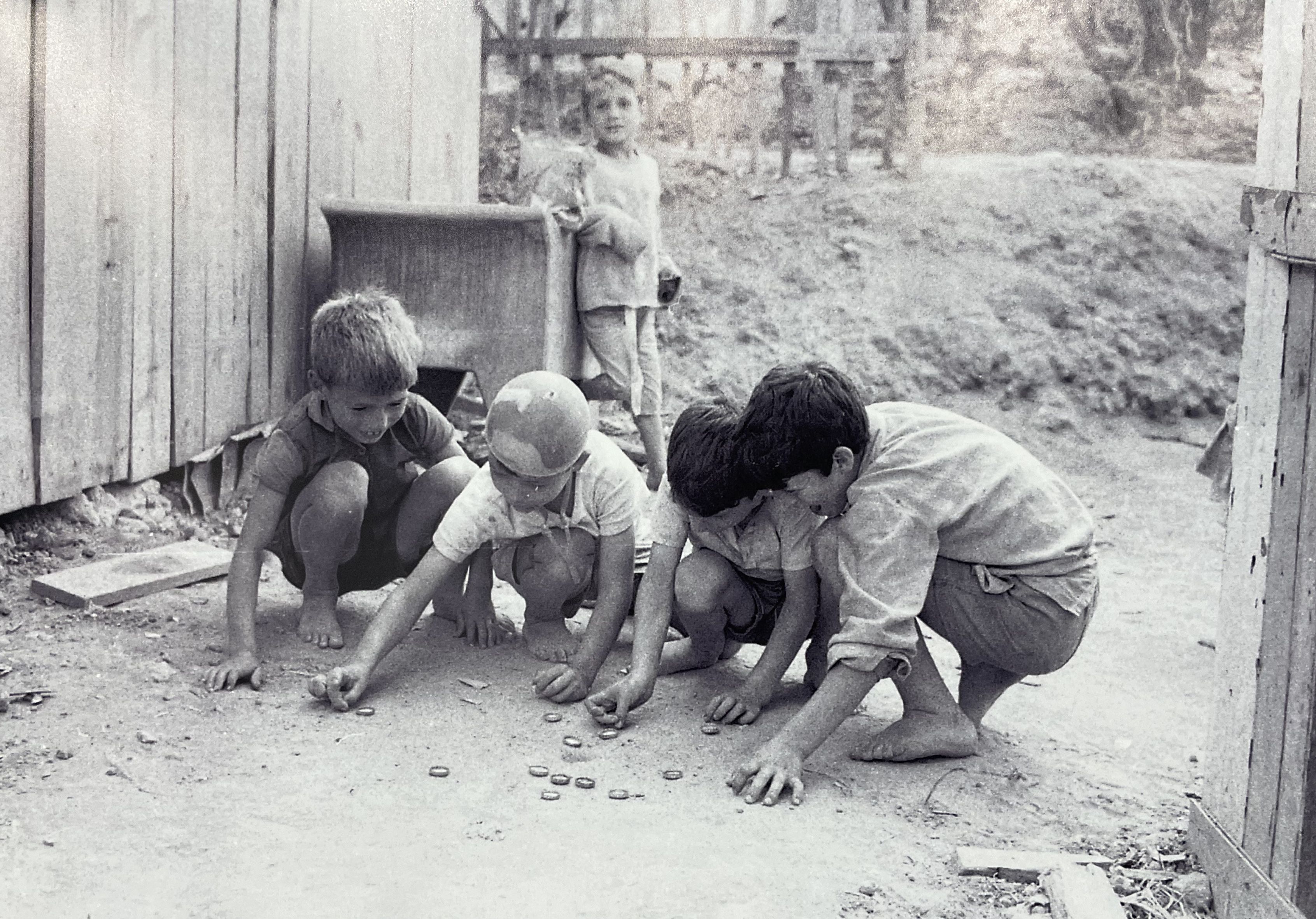 Un grup de nens jugant al joc dels taps al barri de la Quinta do Nargão. // Imatge de Luís Carvalhido recollida al llibre de Daniel Bastos.
