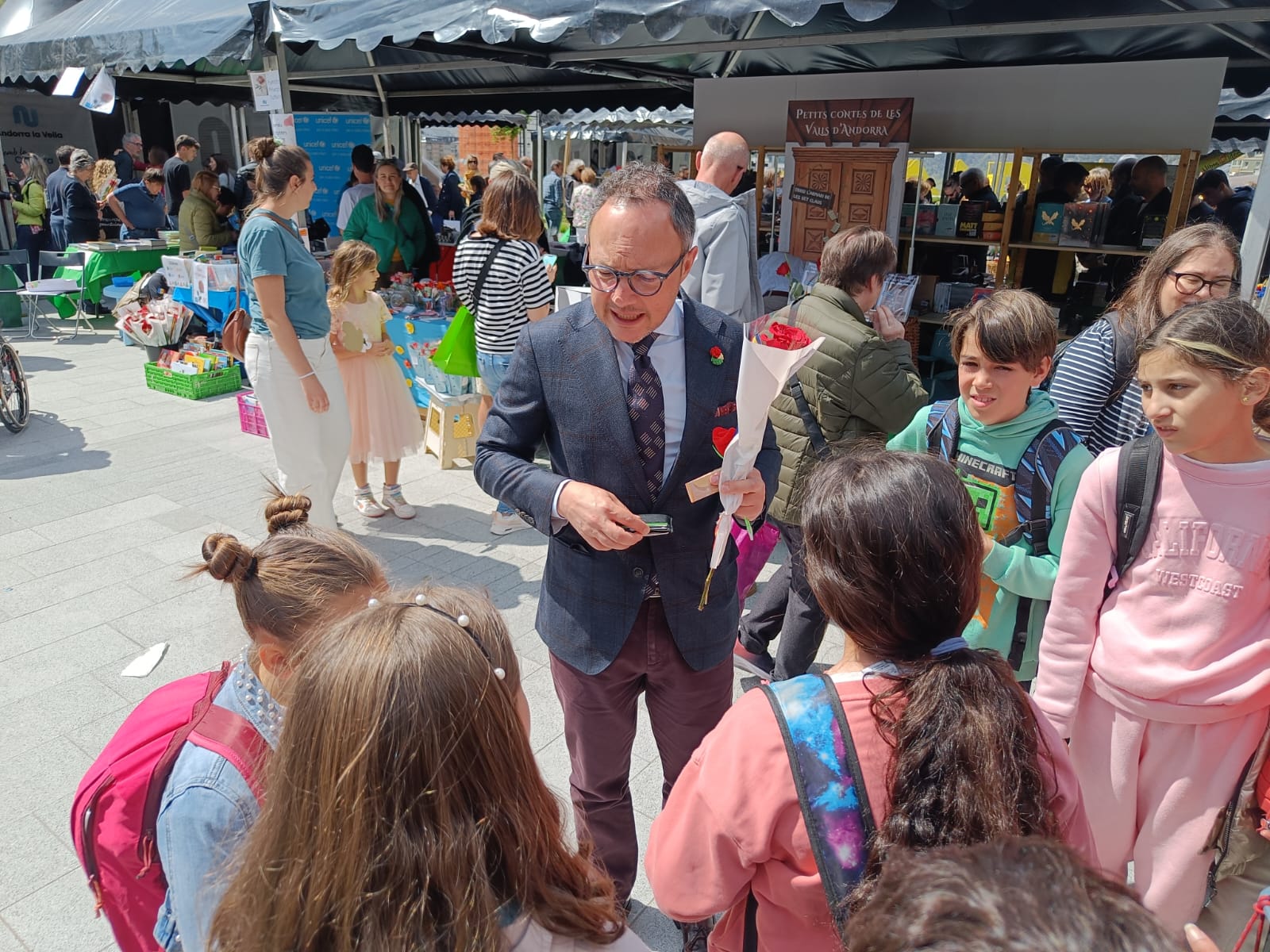 Espot xerra amb uns nens a la plaça del Poble.