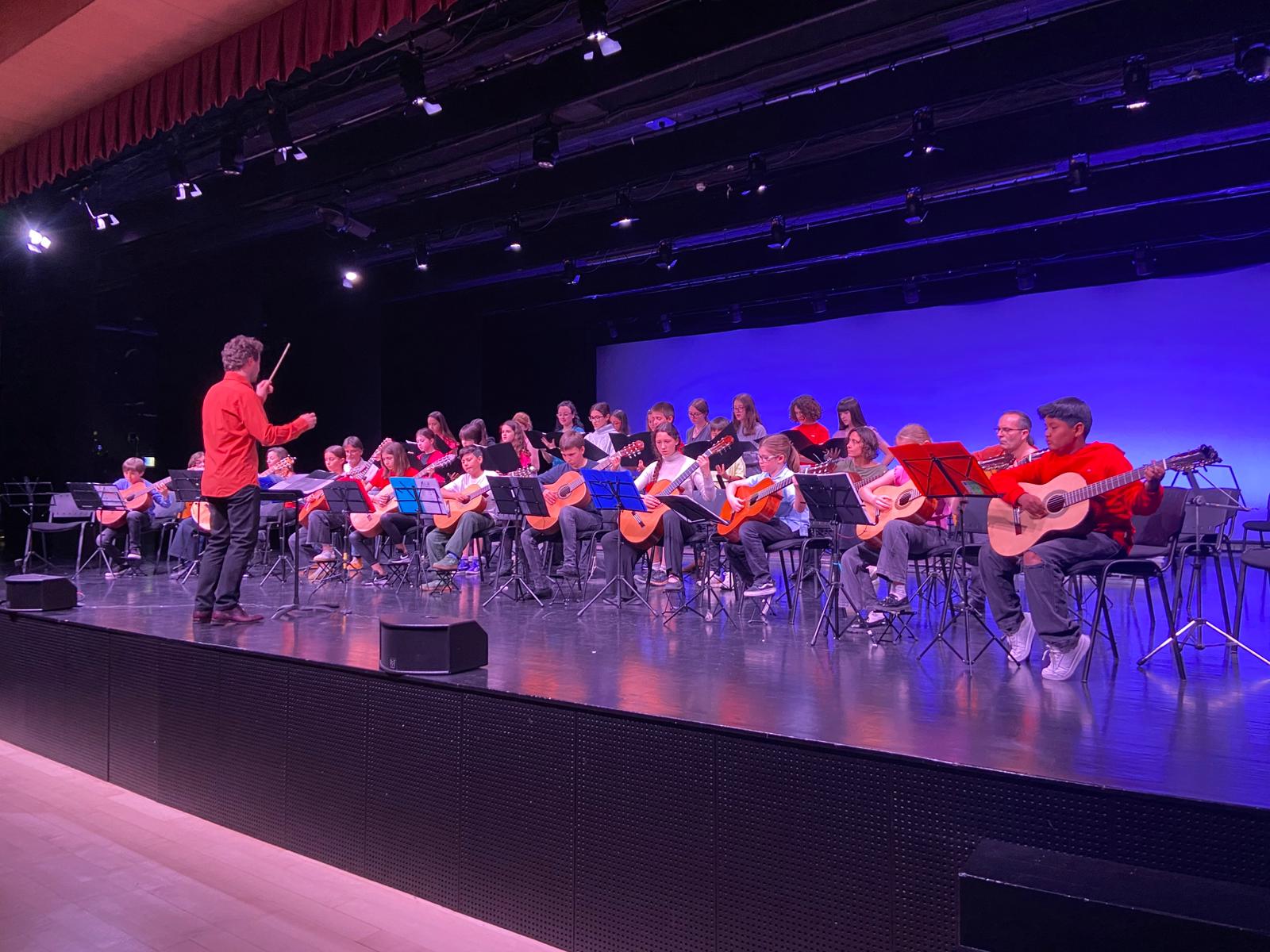 Músics joves, seguint les indicacions del director, durant la trobada de conjunts de guitarra. 