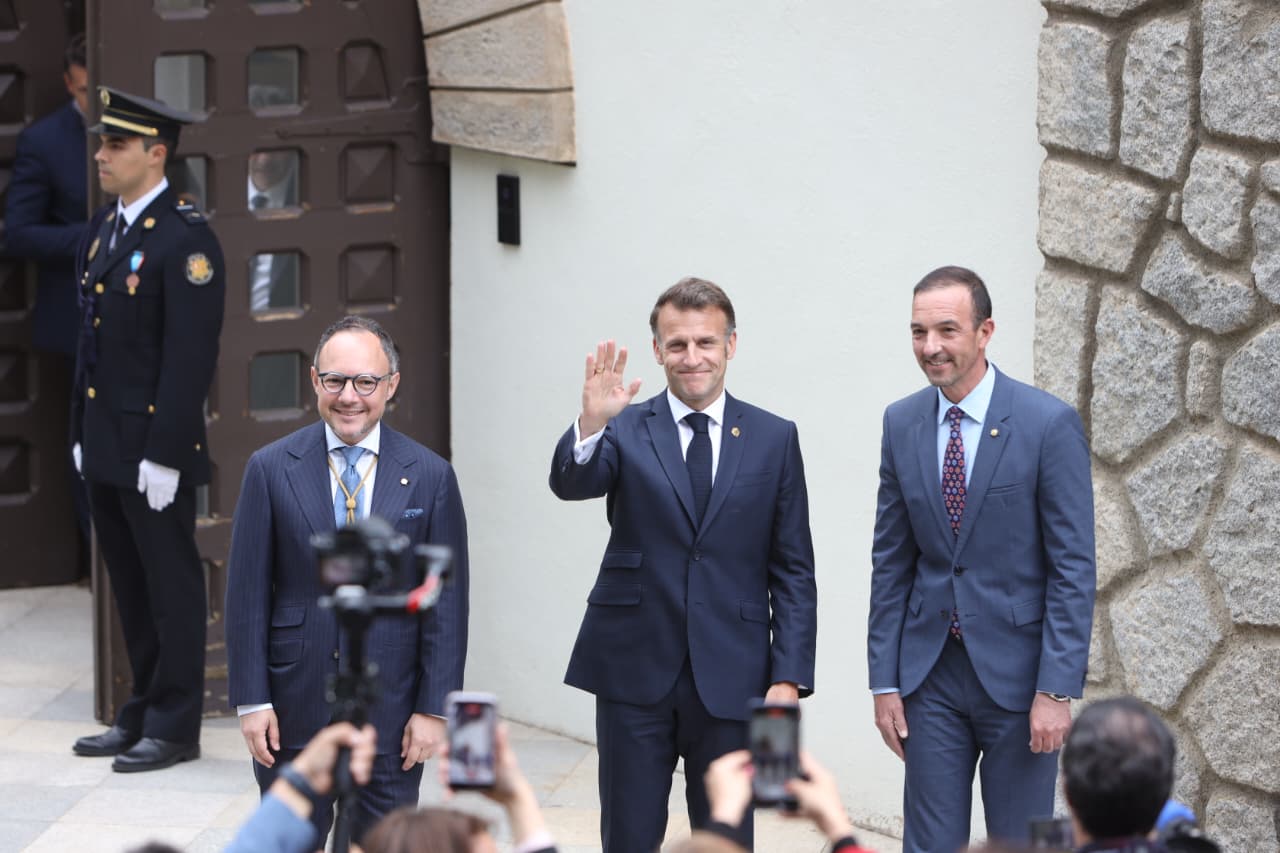 Macron saludant des la porta de Ràdio Andorra flanquejat per Espot i Torres.