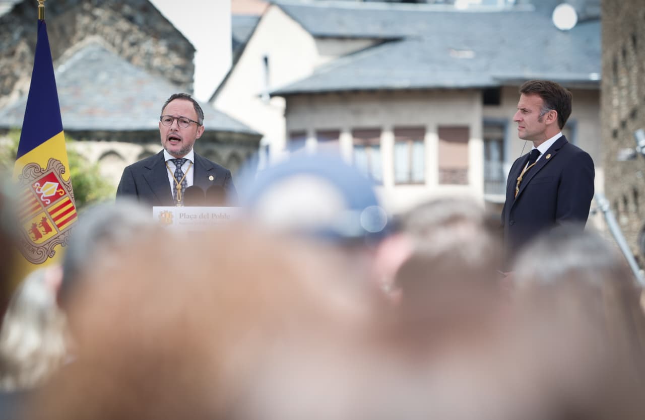 Xavier Espot es dirigeix als assistents a l'acte de la plaça del Poble escoltat per Emmanuel Macron, que ha aguantat un discurs llarguíssim.