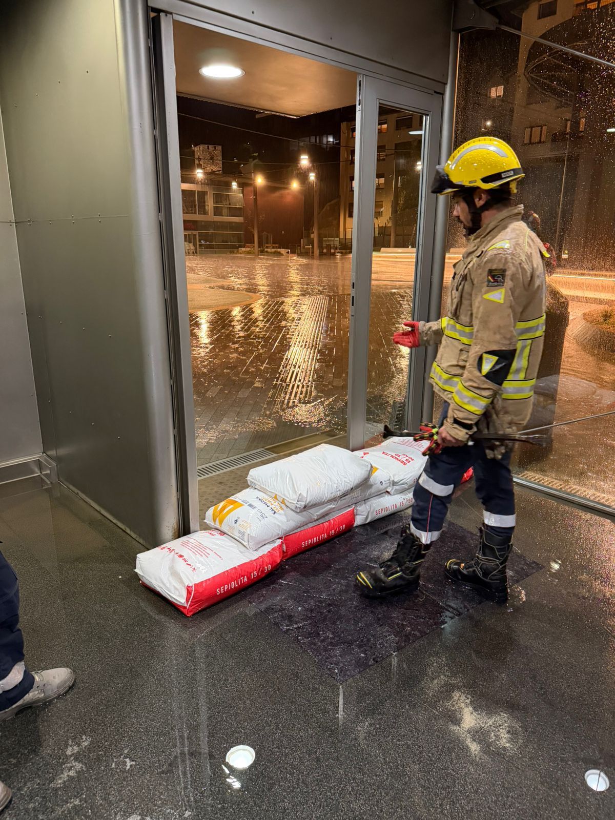 Un bomber observant el 'dic de sepiolita' per mirar de frenar l'aigua.