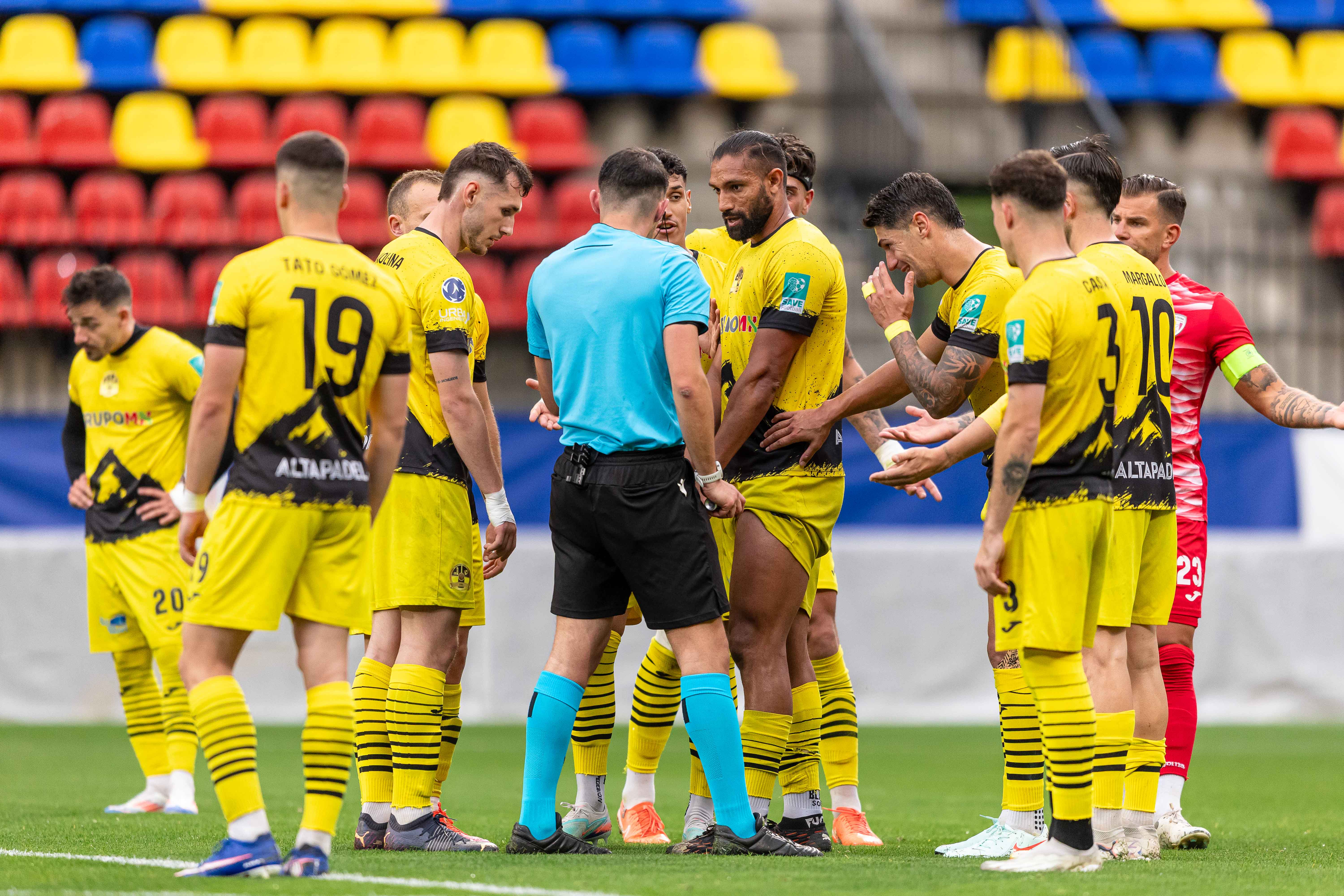 Jugadors de la UE Santa Coloma envolten l'àrbitre en un dels darrers partits de lliga.
