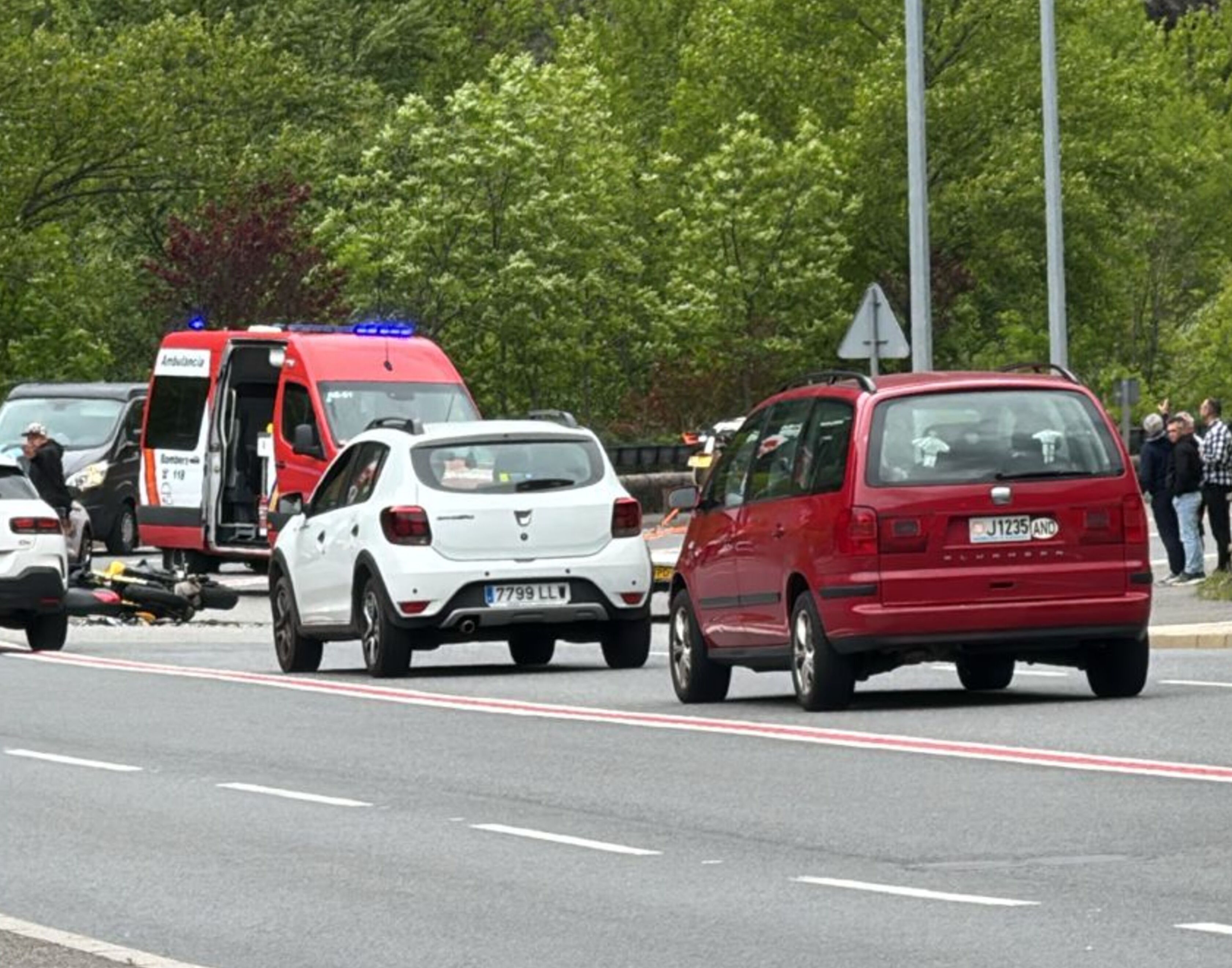 Els sanitaris dels bombers atenent el pilot de la moto, encara damunt l'asfalt.