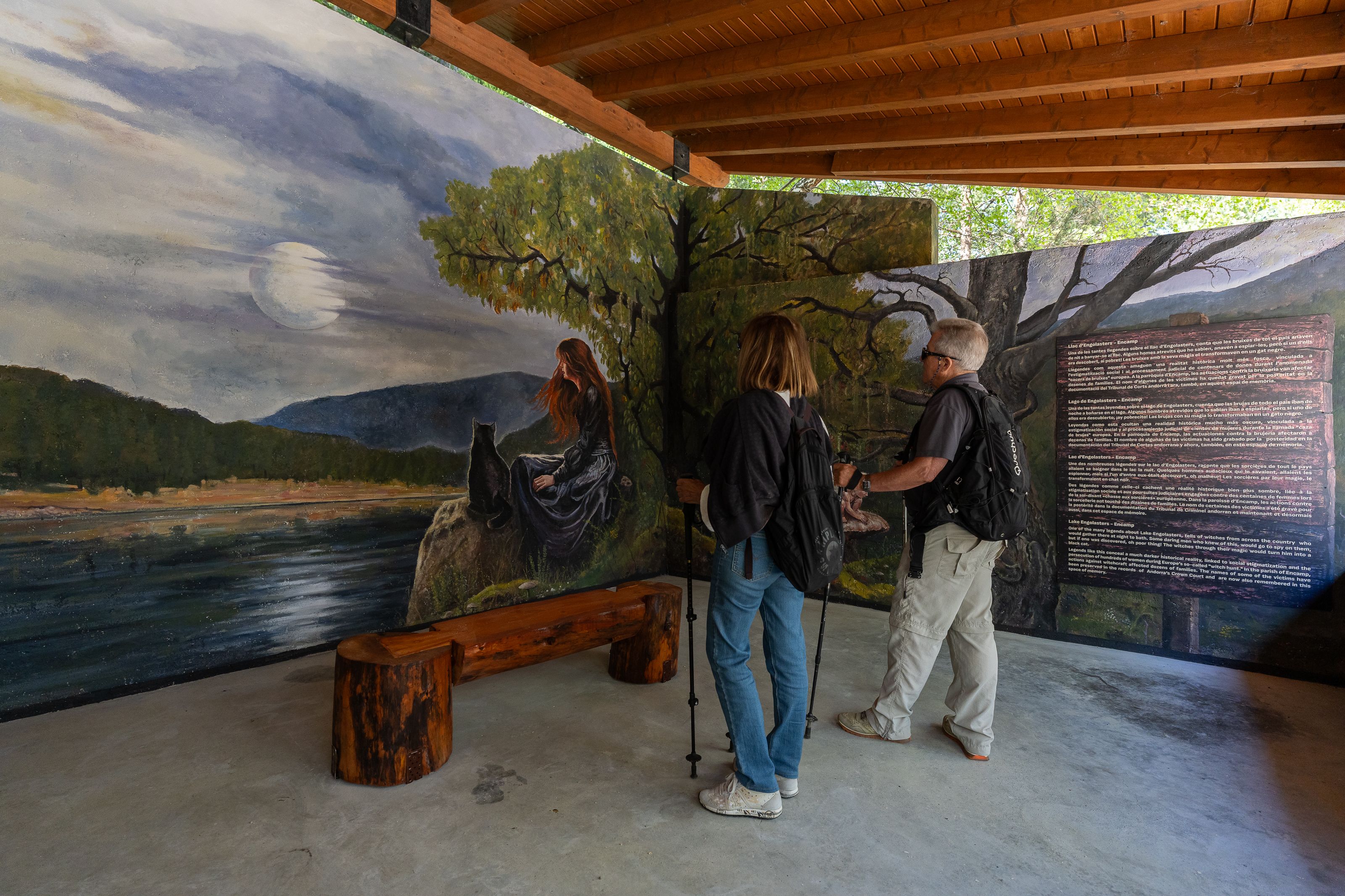 Dos visitants contemplant el mural interior de l'aixopluc. // Comú d'Encamp