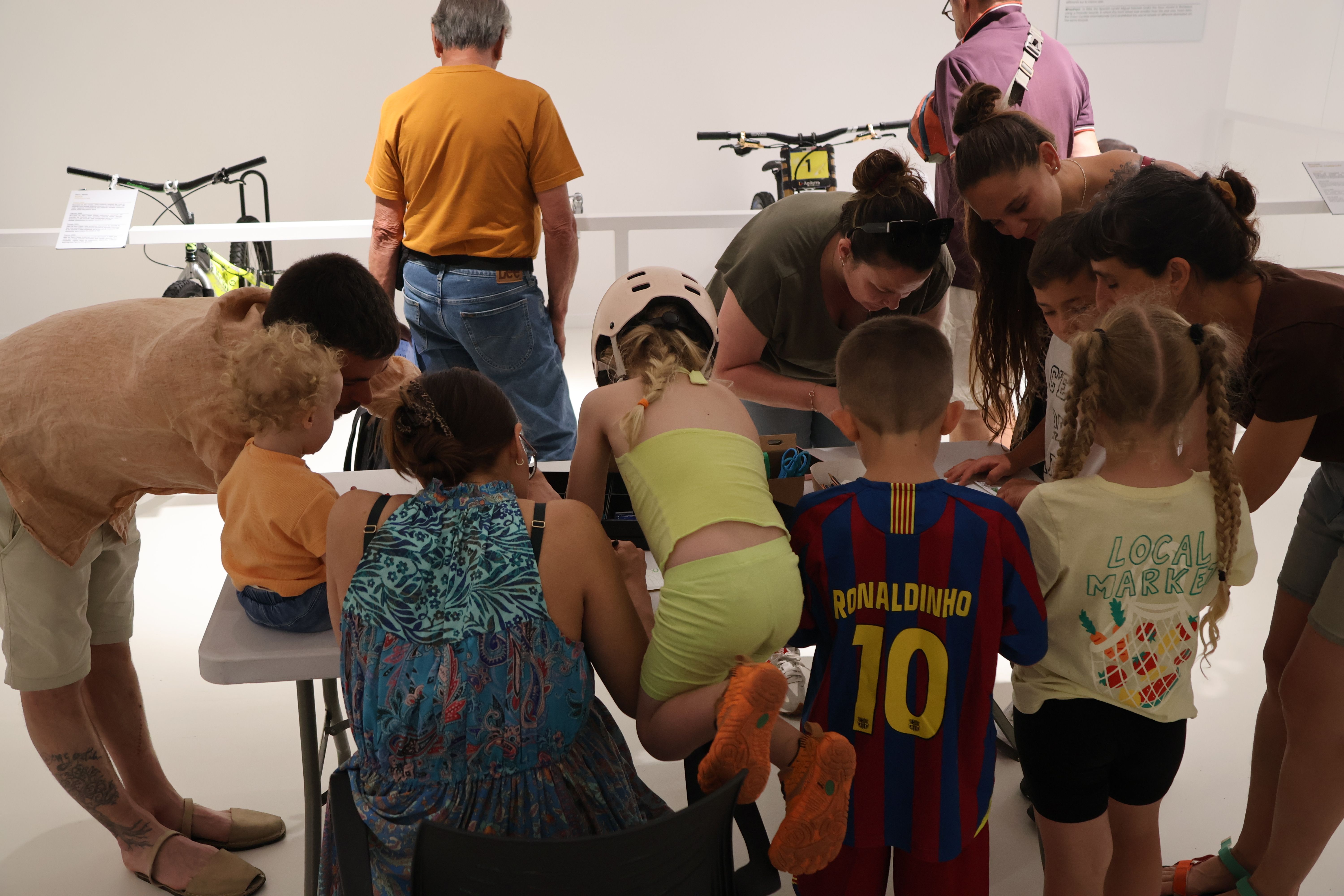 Un grup d'infants fent el taller de tunejar la bicicleta. La portaveu del Sindicat, Rebeca Bonache.
