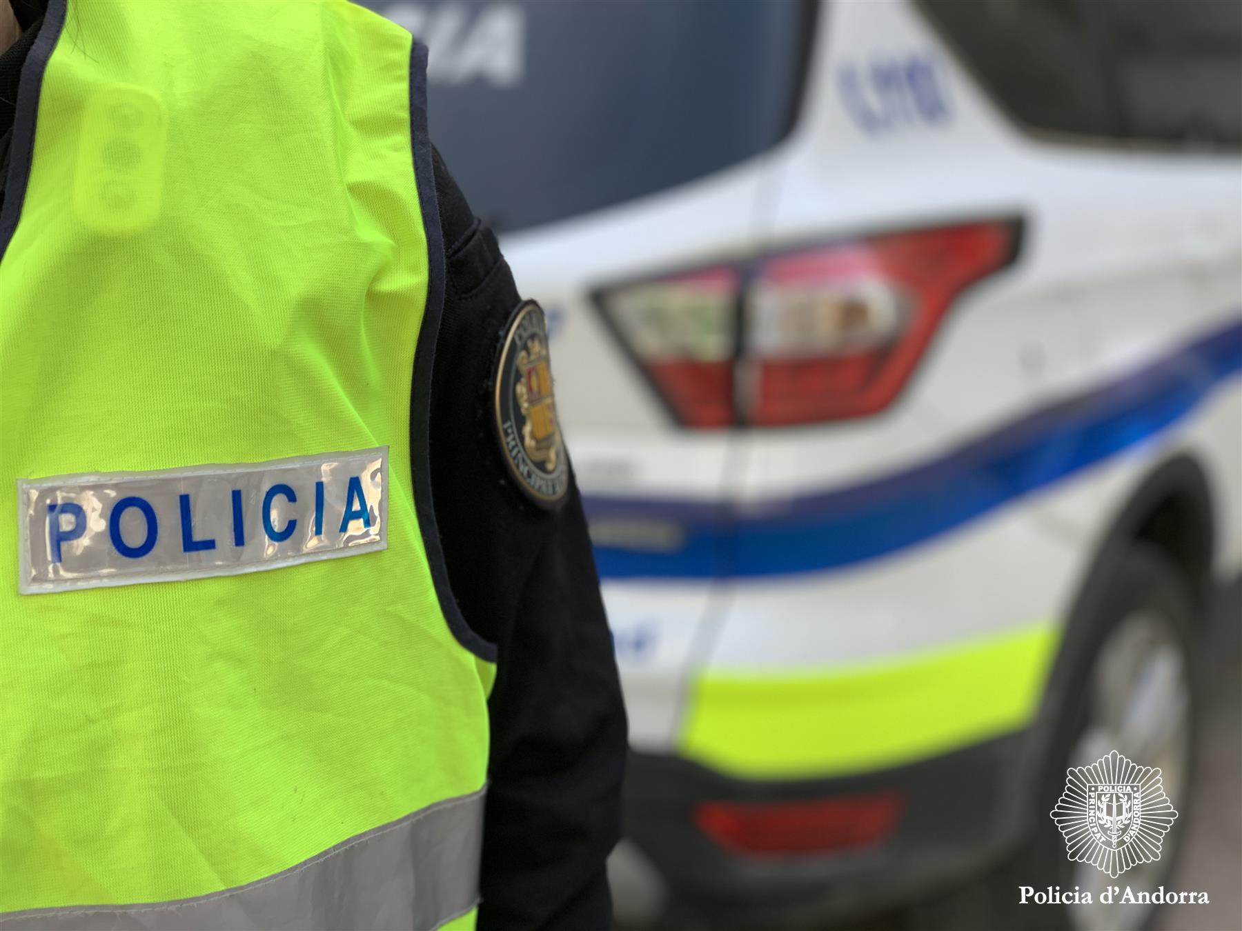 Un funcionari de policia davant d'un cotxe del cos. Un funcionari de policia davant d'un cotxe del cos.