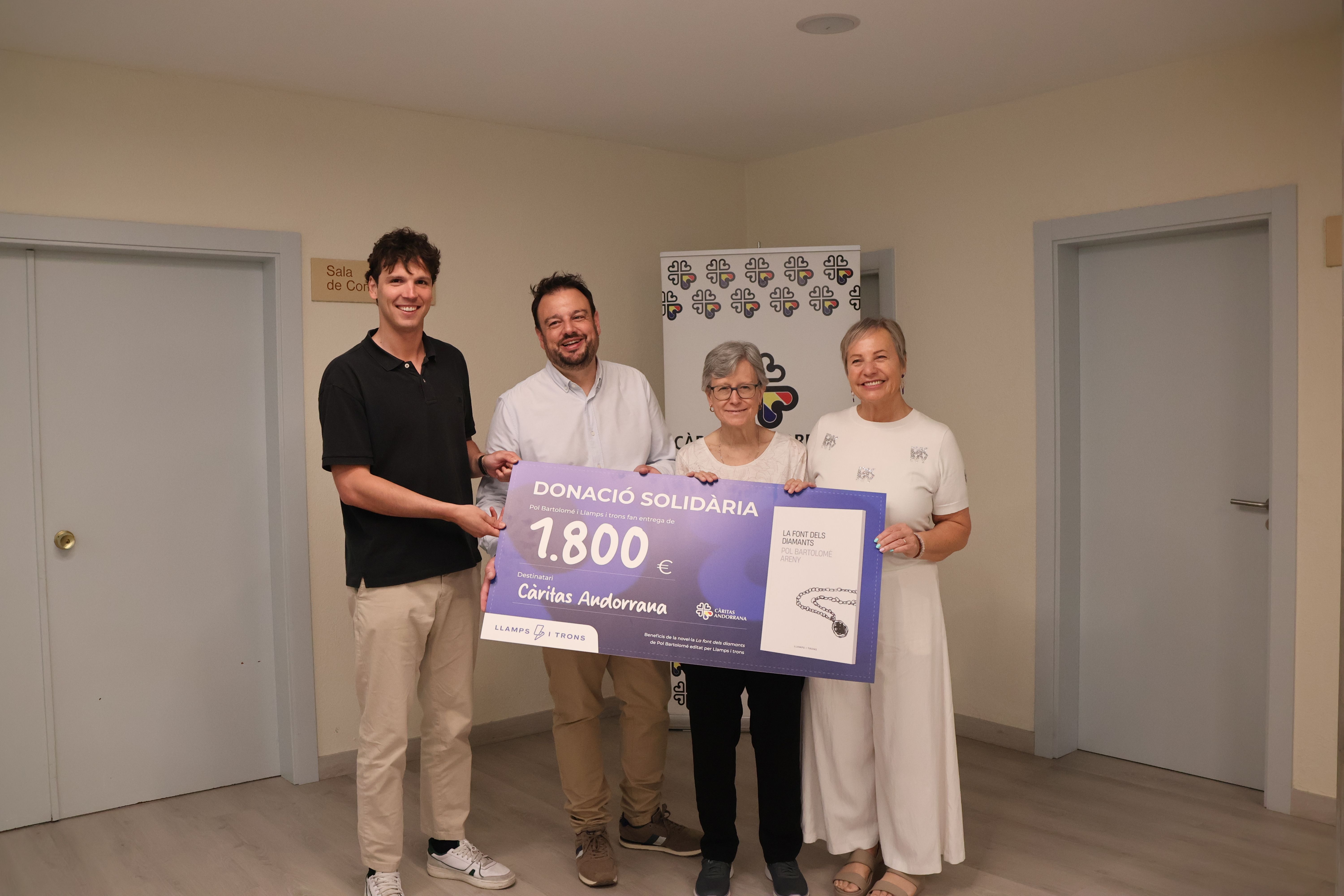 Pol Bartolomé entrega un xec de 1.800 euros a Càritas de les vendes del seu llibre ‘La font dels diamants’.