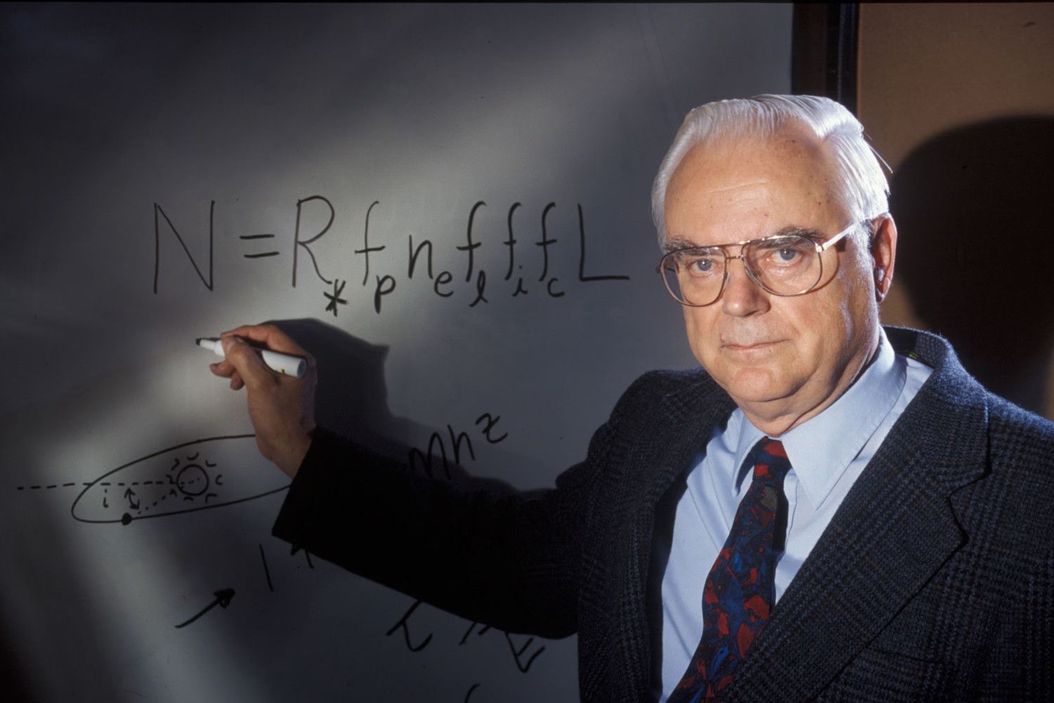 Frank Drake posant davant de la seva equació - Crèdit: SETI Institute La portaveu del Sindicat, Rebeca Bonache.