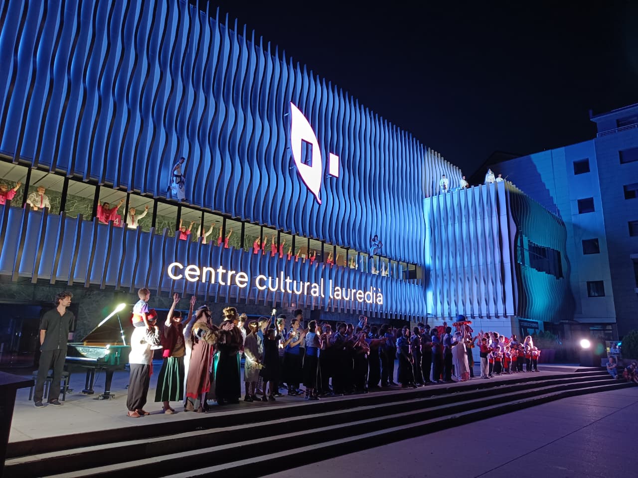 Els participants a l'espectacle inaugural davant la nova façana del Centre Cultural Lauredià.