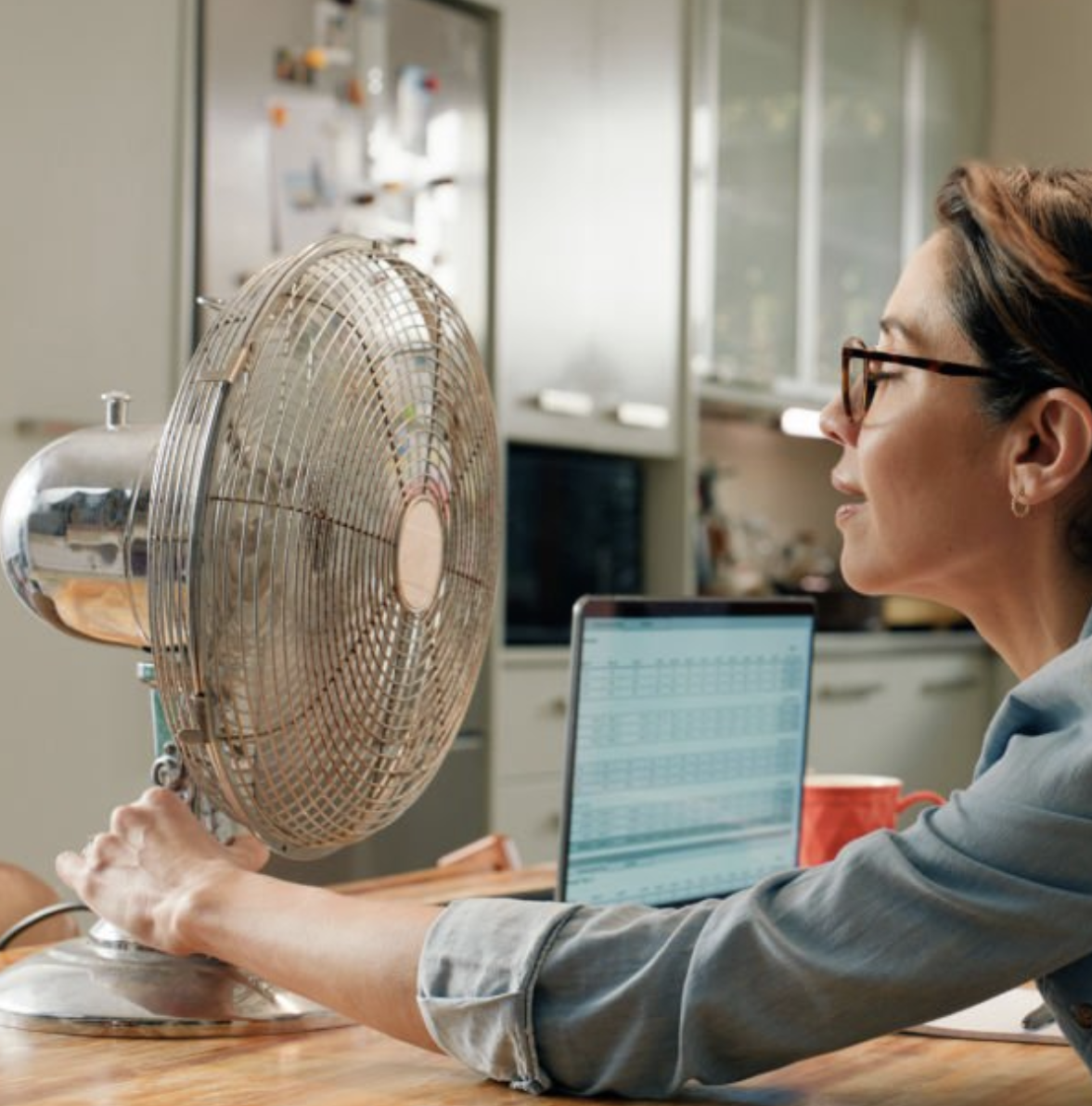 Una dona acostant-se a un ventilador.