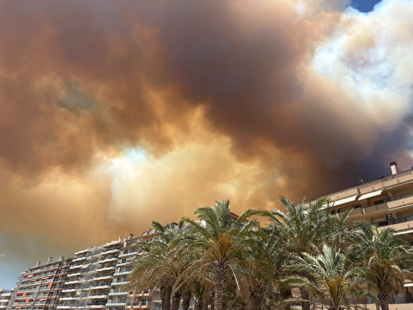 El cel de fum i foc sobre els edificis d'apartaments a Sant Antoni de Calonge.
