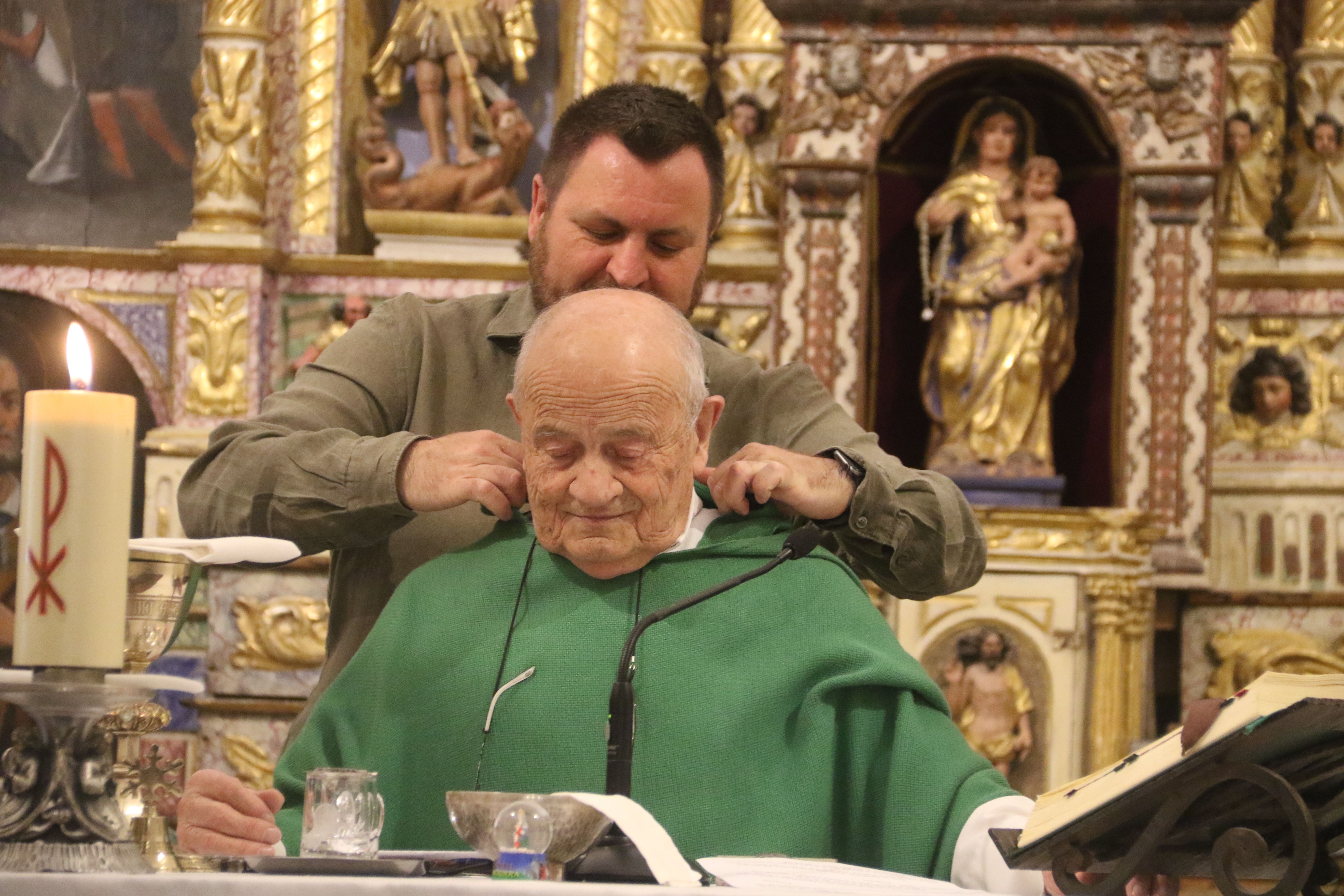 El director de Cultura del comú, Roberto Lizarte, col·locant bé la casulla al mossèn.