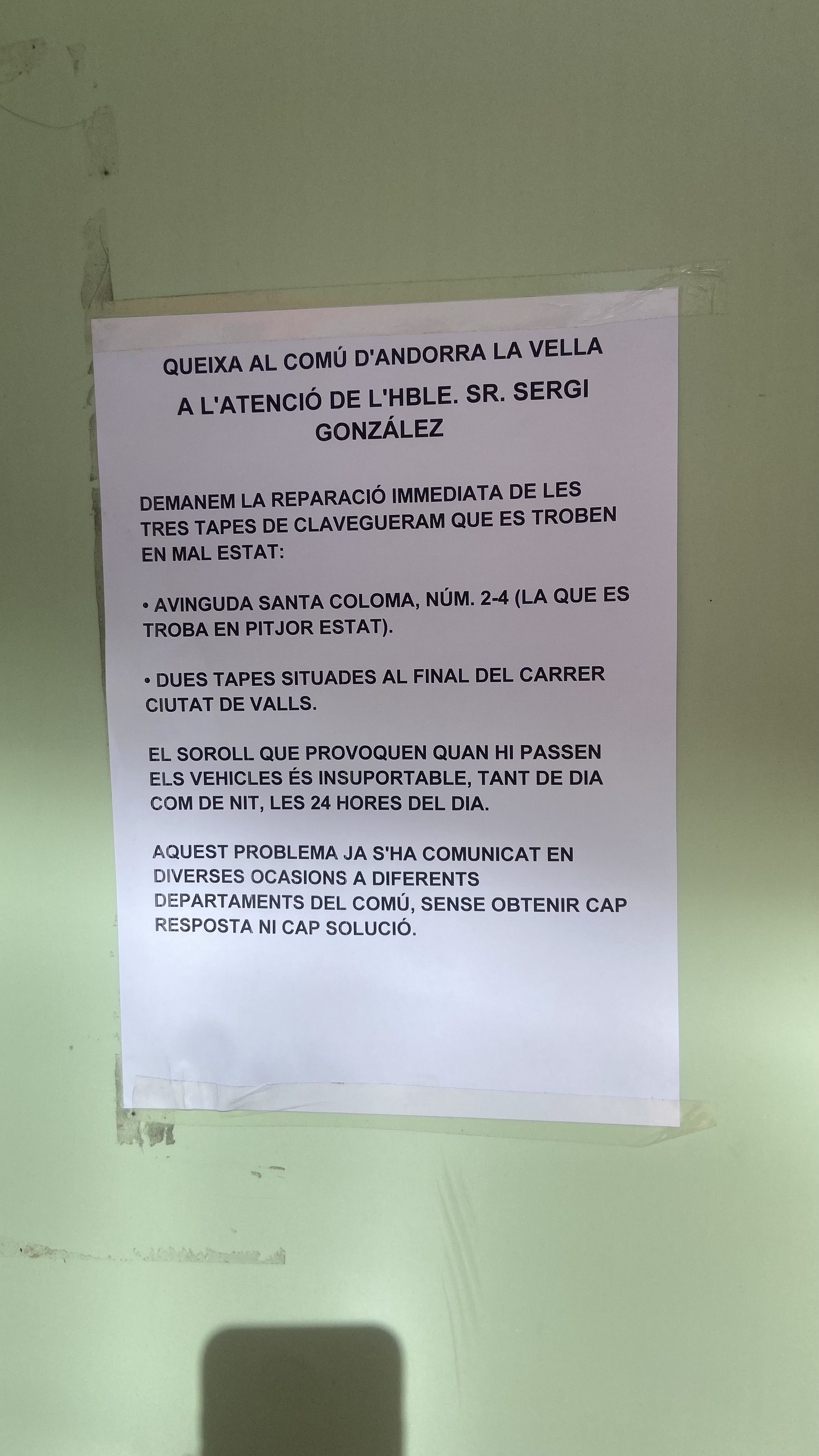 Un cartell de queixa pel soroll de les tapes del clavegueram.