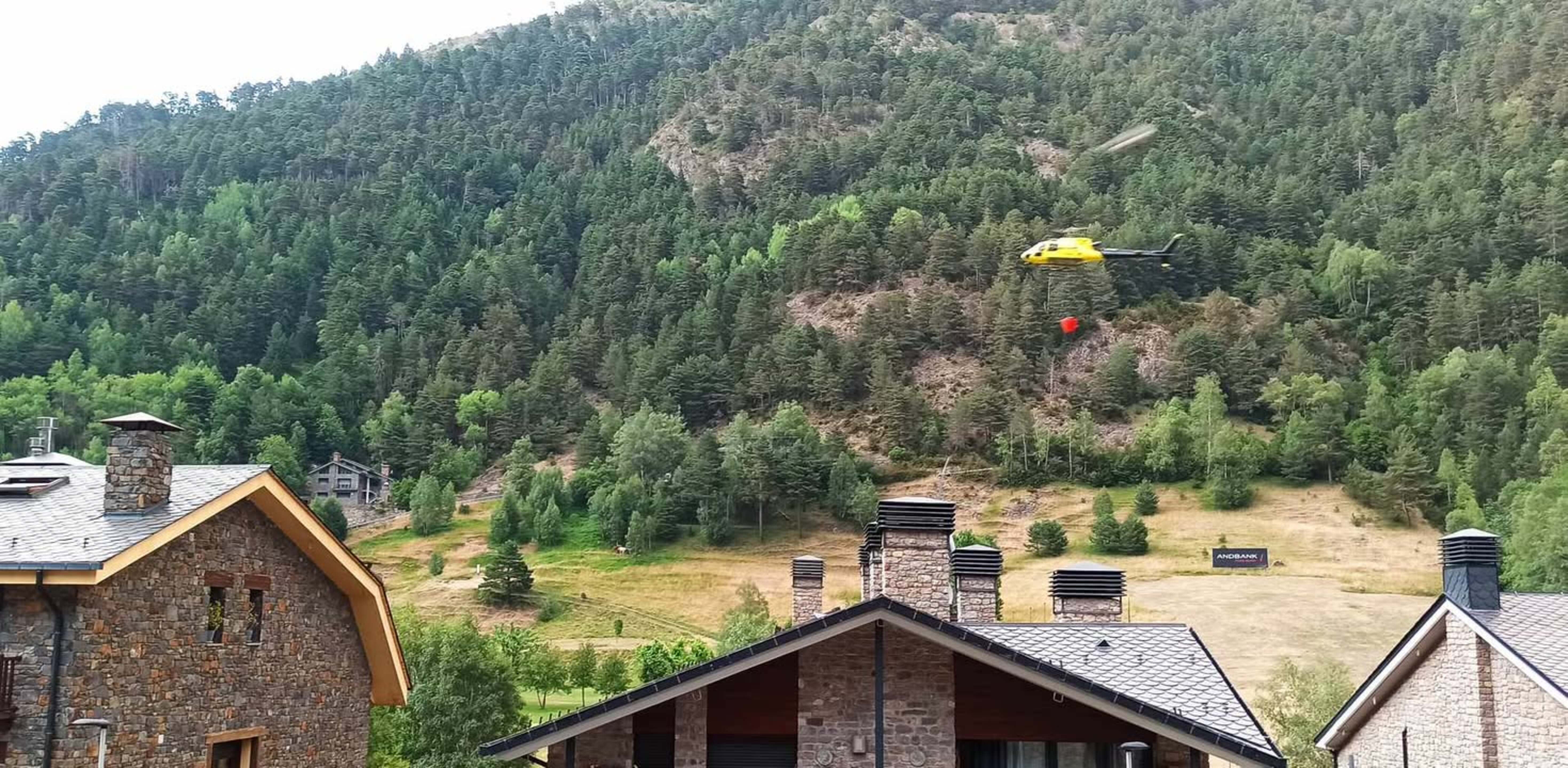 L'helicópter carregat d'aigua actuant en la zona. L'helicópter carregat d'aigua actuant en la zona.
