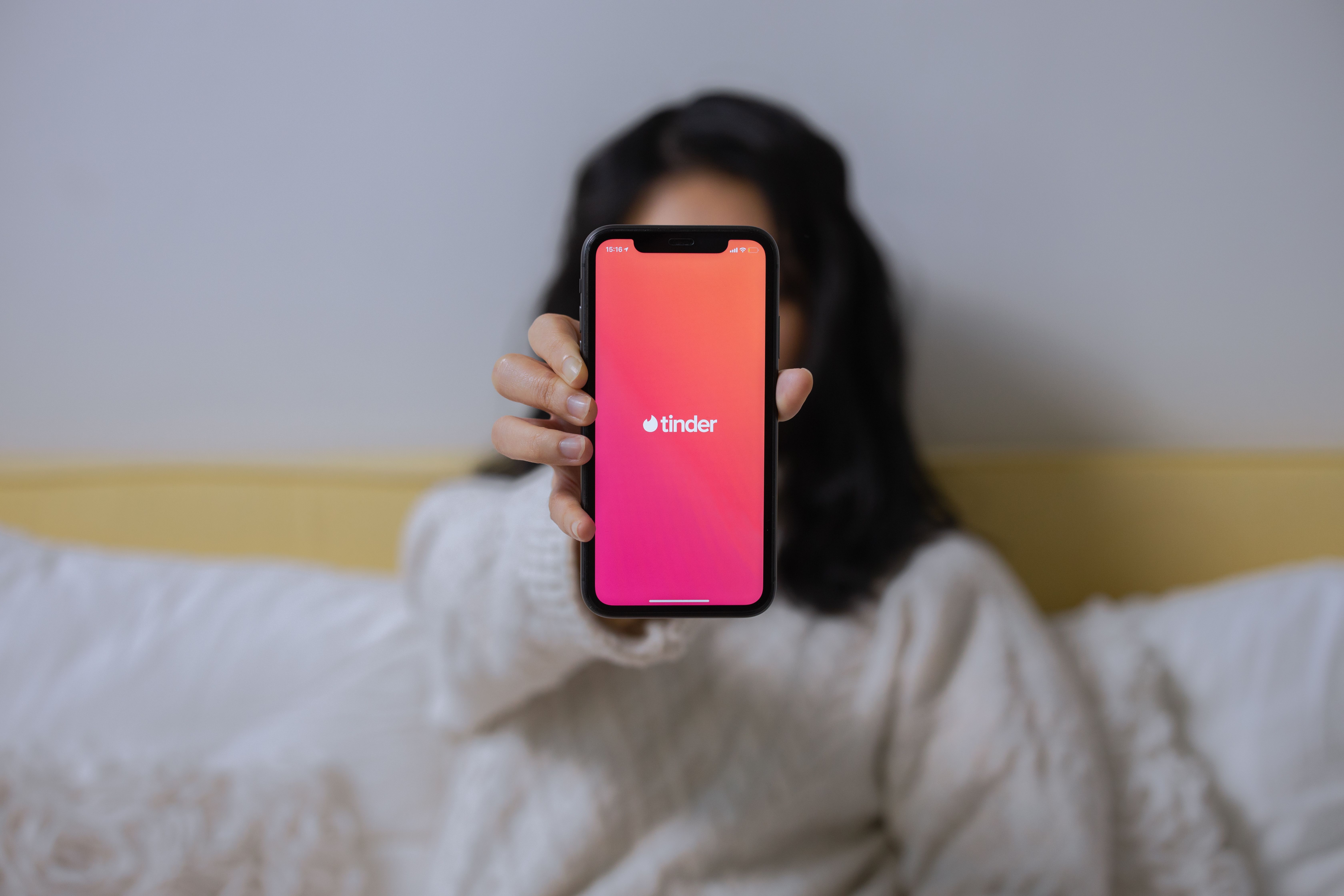 Una noia mostra un mòbil amb l'aplicació Tinder. Una noia mostra un mòbil amb l'aplicació Tinder.