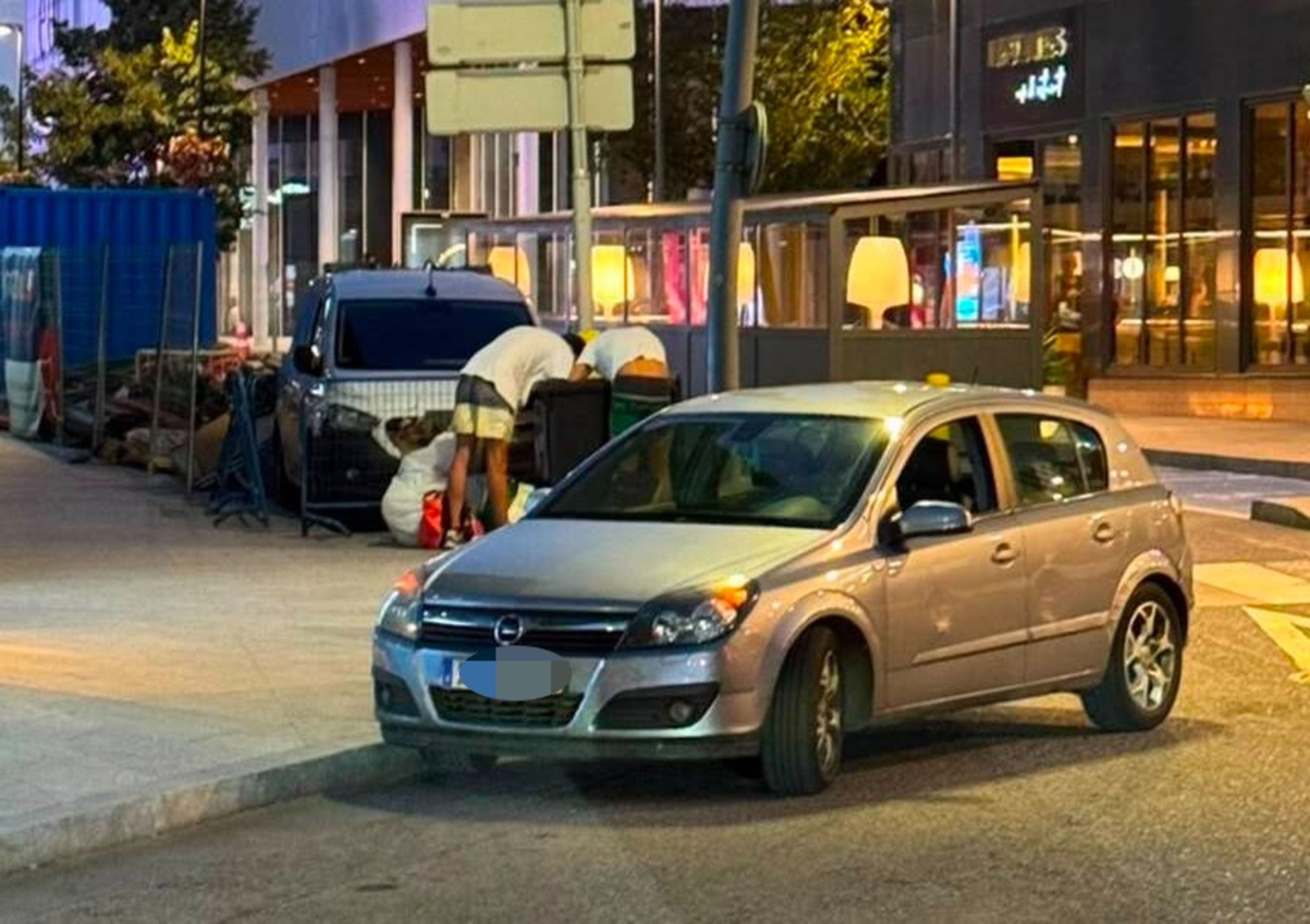 Els dos joves furgant al contenidor amb el cotxe amb el qual es mourien estacionat just davant. Els dos joves furgant al contenidor amb el cotxe amb el qual es mourien estacionat just davant.