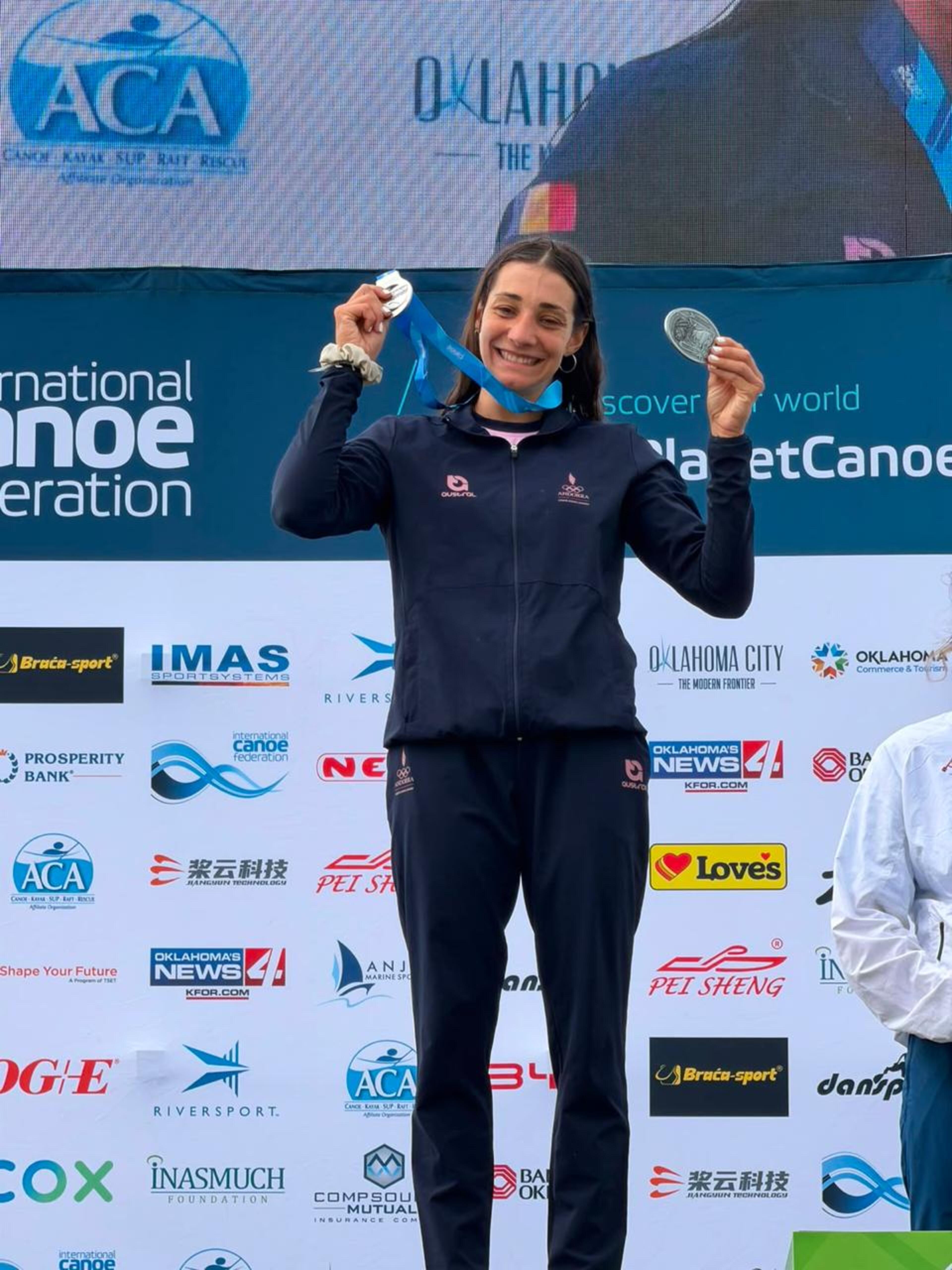 Mònica Doria mostrant la medalla de plata al podi.