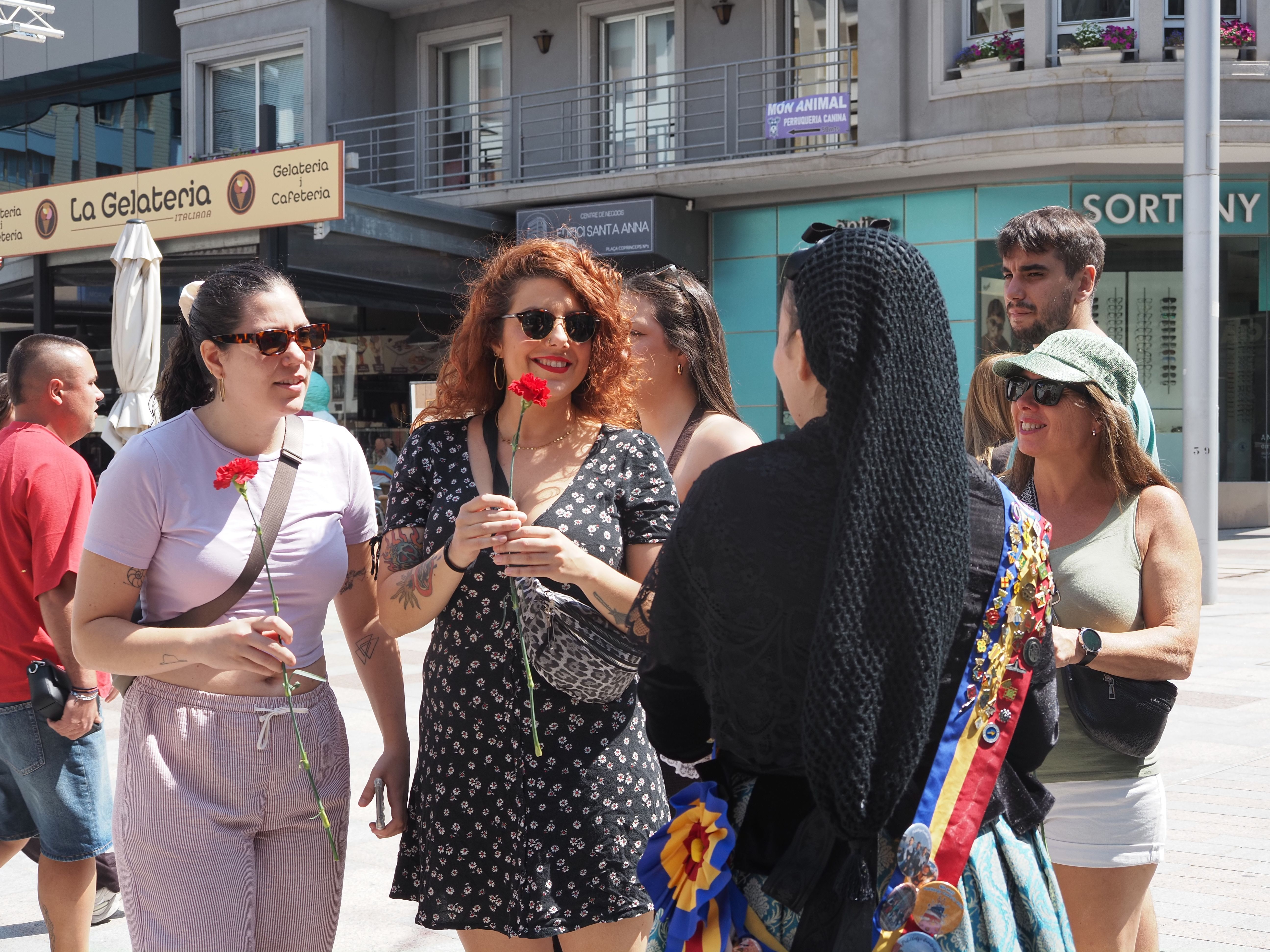 Turistes amb el clavells entregats pels membres del pubillatge d'Escaldes-Engordany. Turistes amb el clavells entregats pels membres del pubillatge d'Escaldes-Engordany.