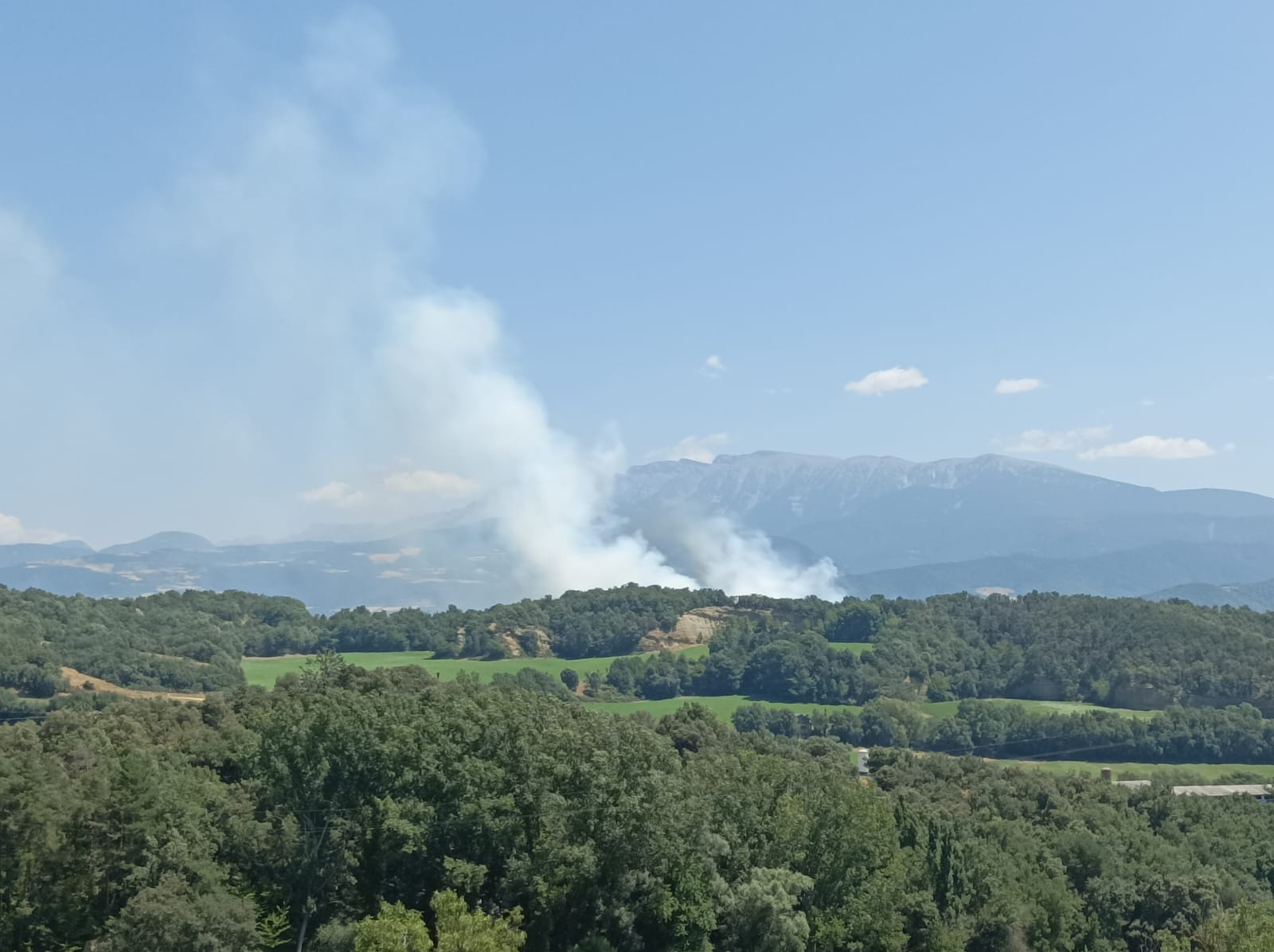Els bombers catalans treballen per apagar un incendi de vegetació agrícola a prop de Castellciutat