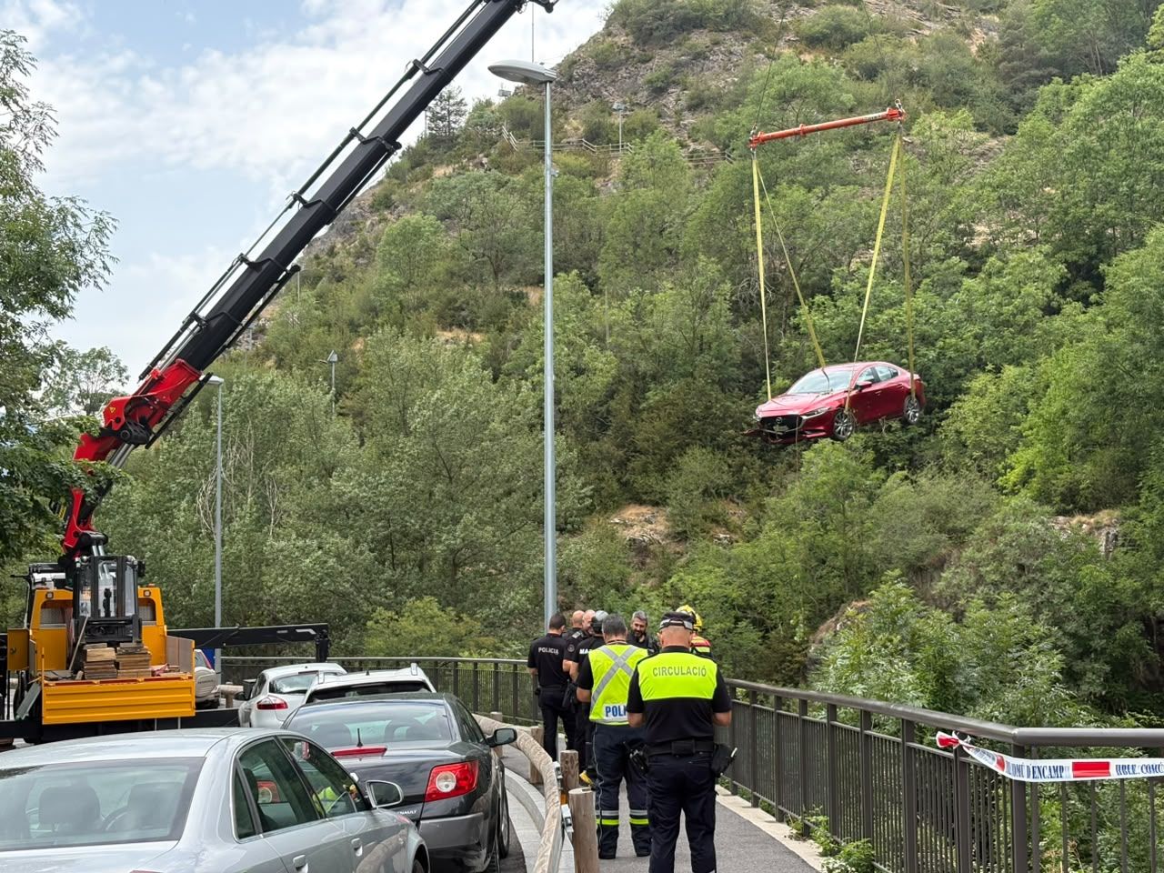 Una grua rescatant el cotxe que havia arribat pràcticament al riu. Una grua rescatant el cotxe que havia arribat pràcticament al riu.