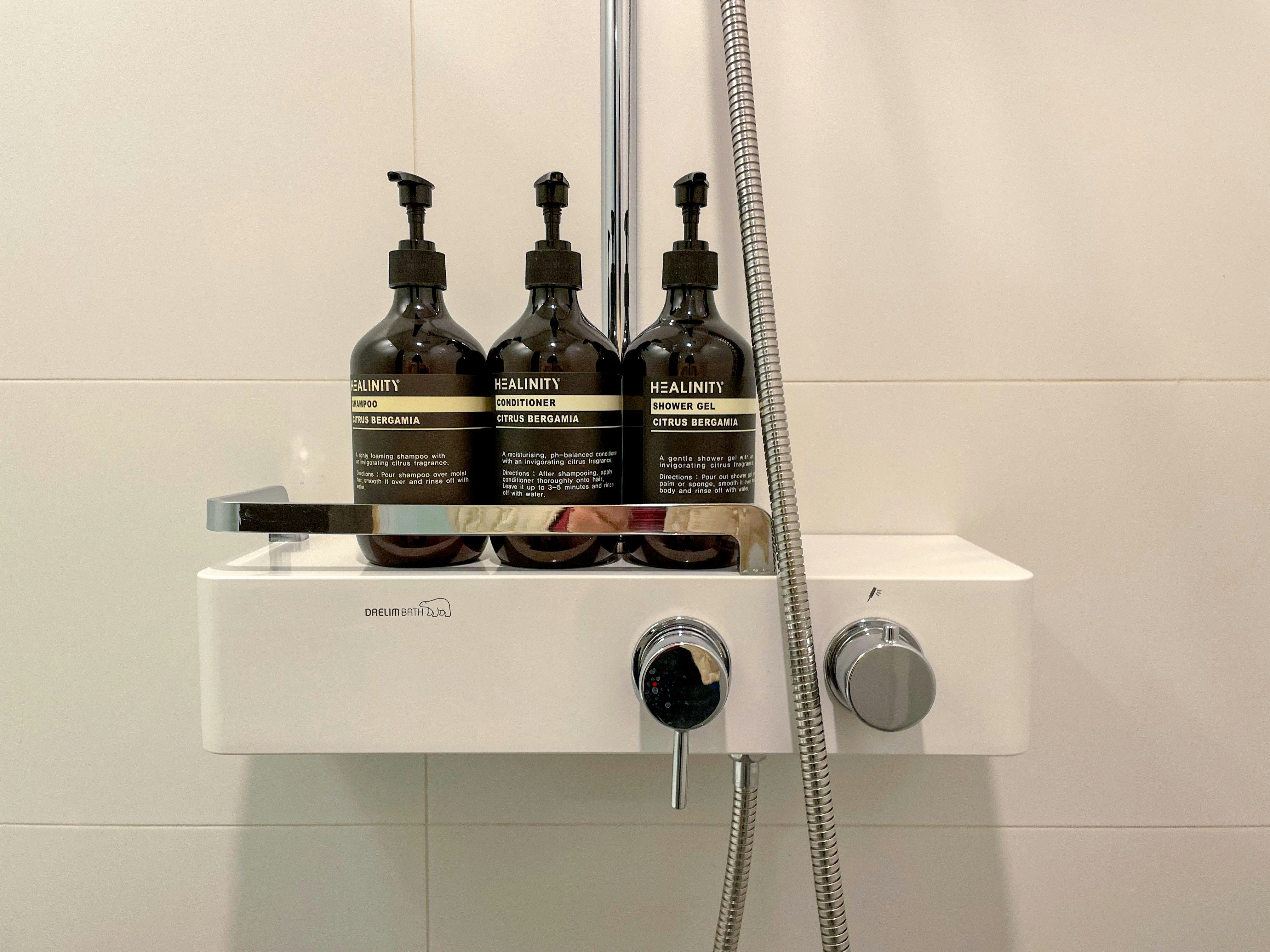 Dispensadors de xampú, condicionador i gel en gran format en un bany d’hotel. Dispensadors de xampú, condicionador i gel en gran format en un bany d’hotel.