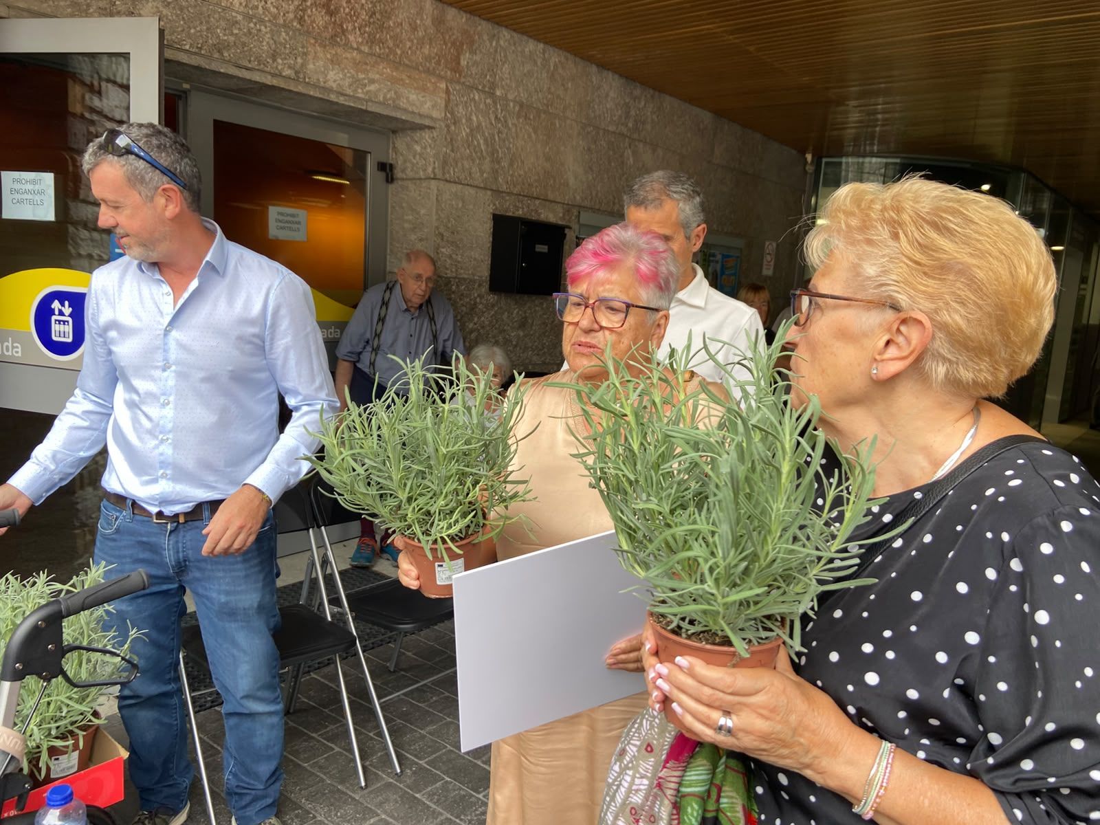 Dues dones recollint l'obsequi floral. Dues dones recollint l'obsequi floral.