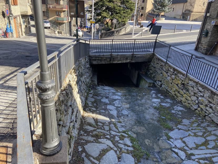 Vista del tram final de la canalització que travessa la carretera a la plaça de l'Església. La portaveu del Sindicat, Rebeca Bonache.