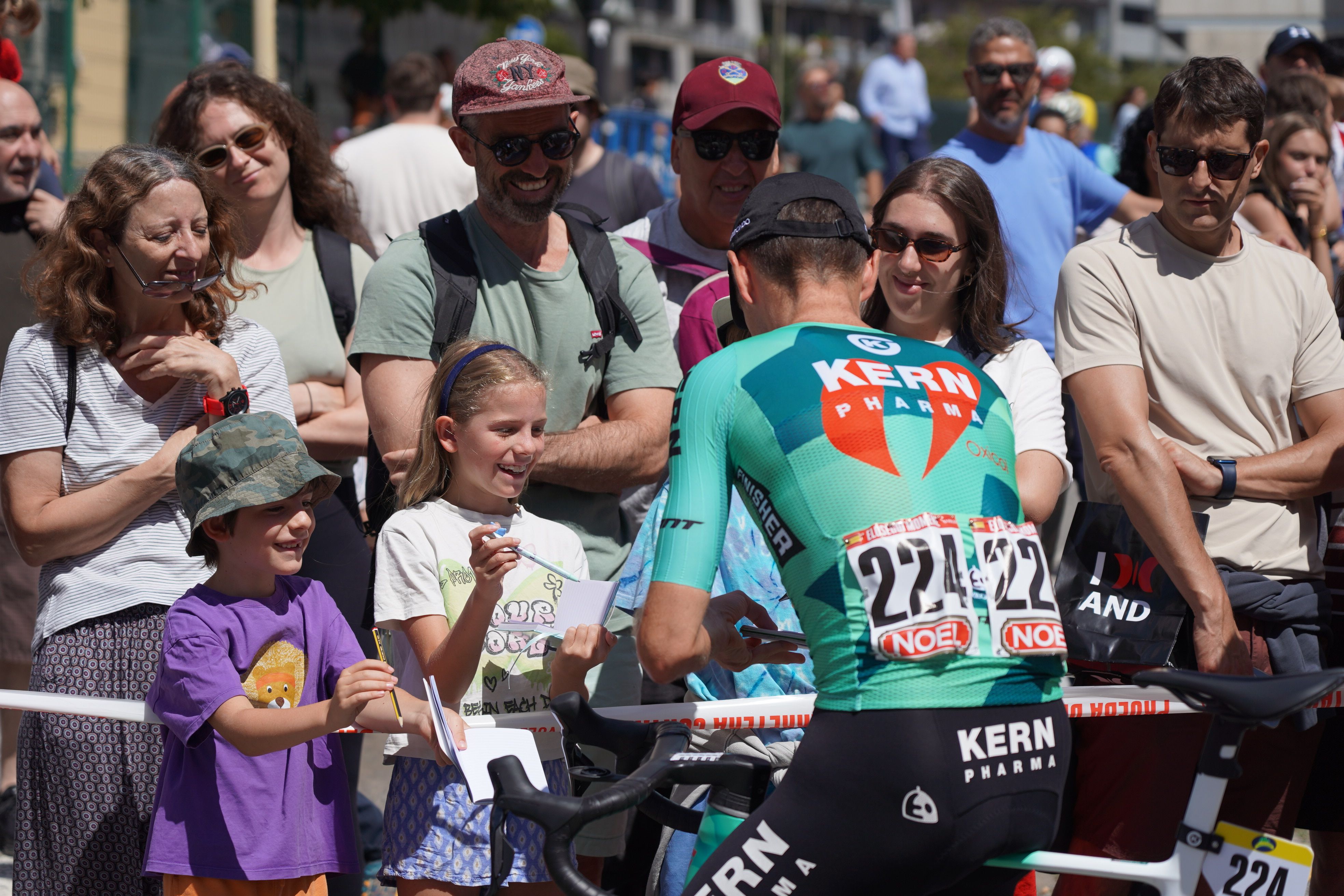 Ciclistes aturant-se a signar als més menuts. Ciclistes aturant-se a signar als més menuts.