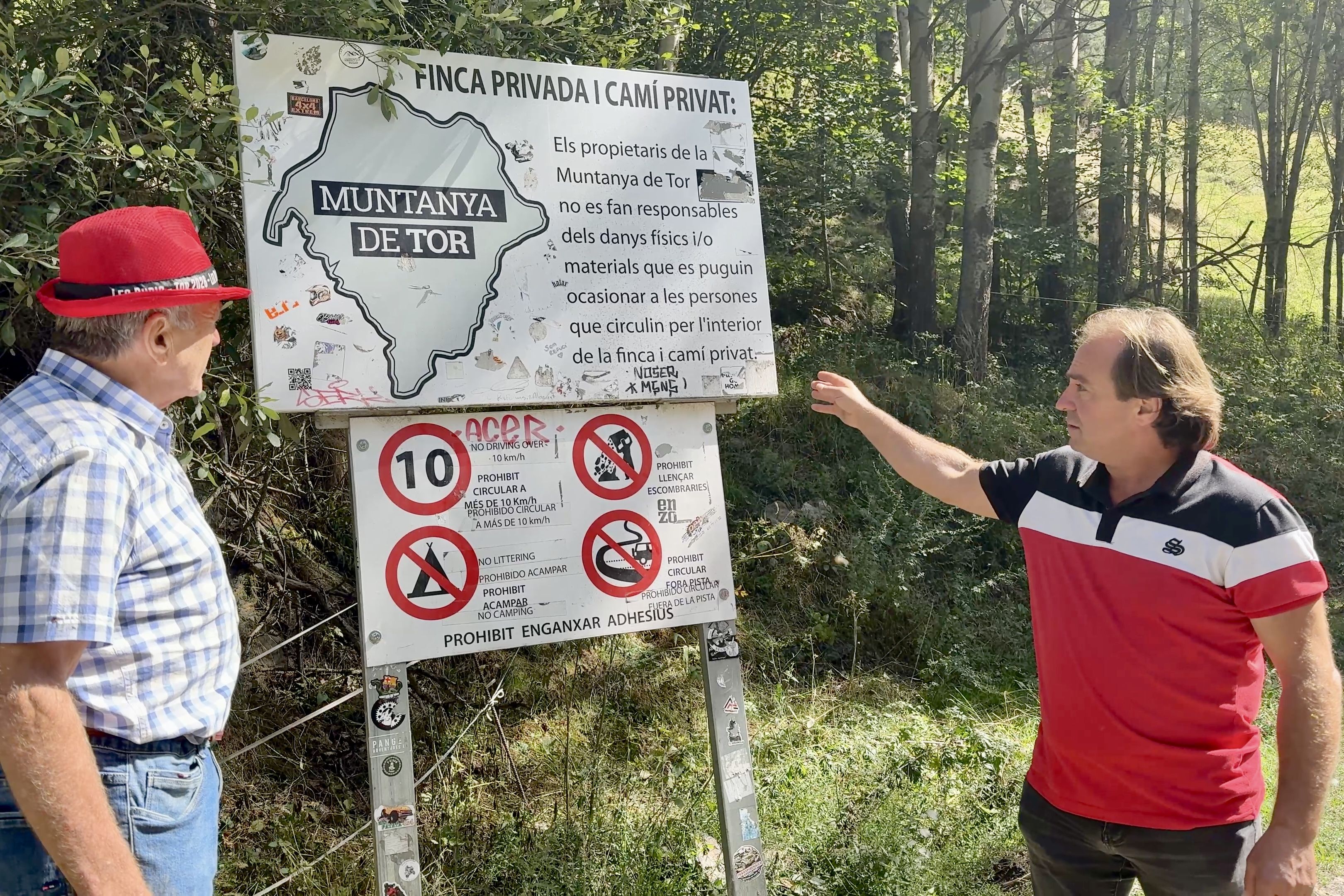 Pablo Moreno mostra el cartell que ja fa anys que està instal·lat a la carretera d'accés a Tor.