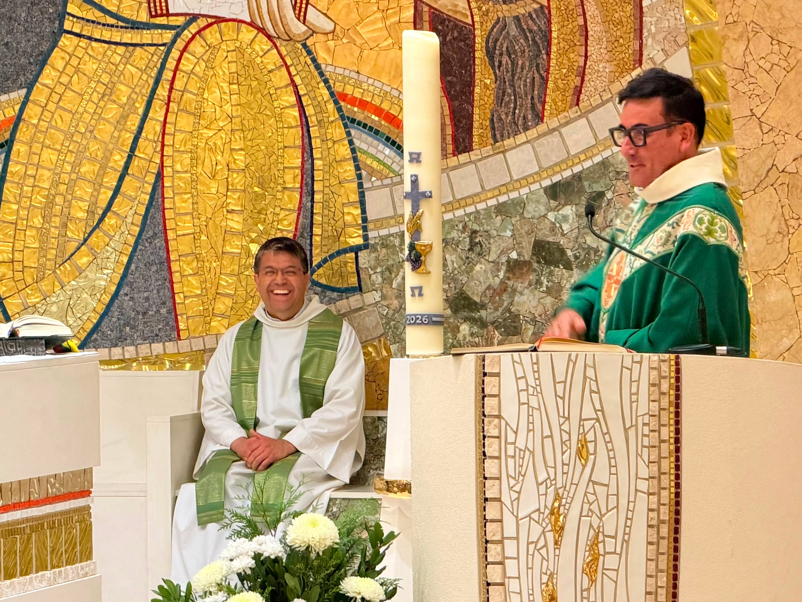Mossèn Pepe adreçant-se als feligresos parlant de Joan Pau Esteban, que somriu.