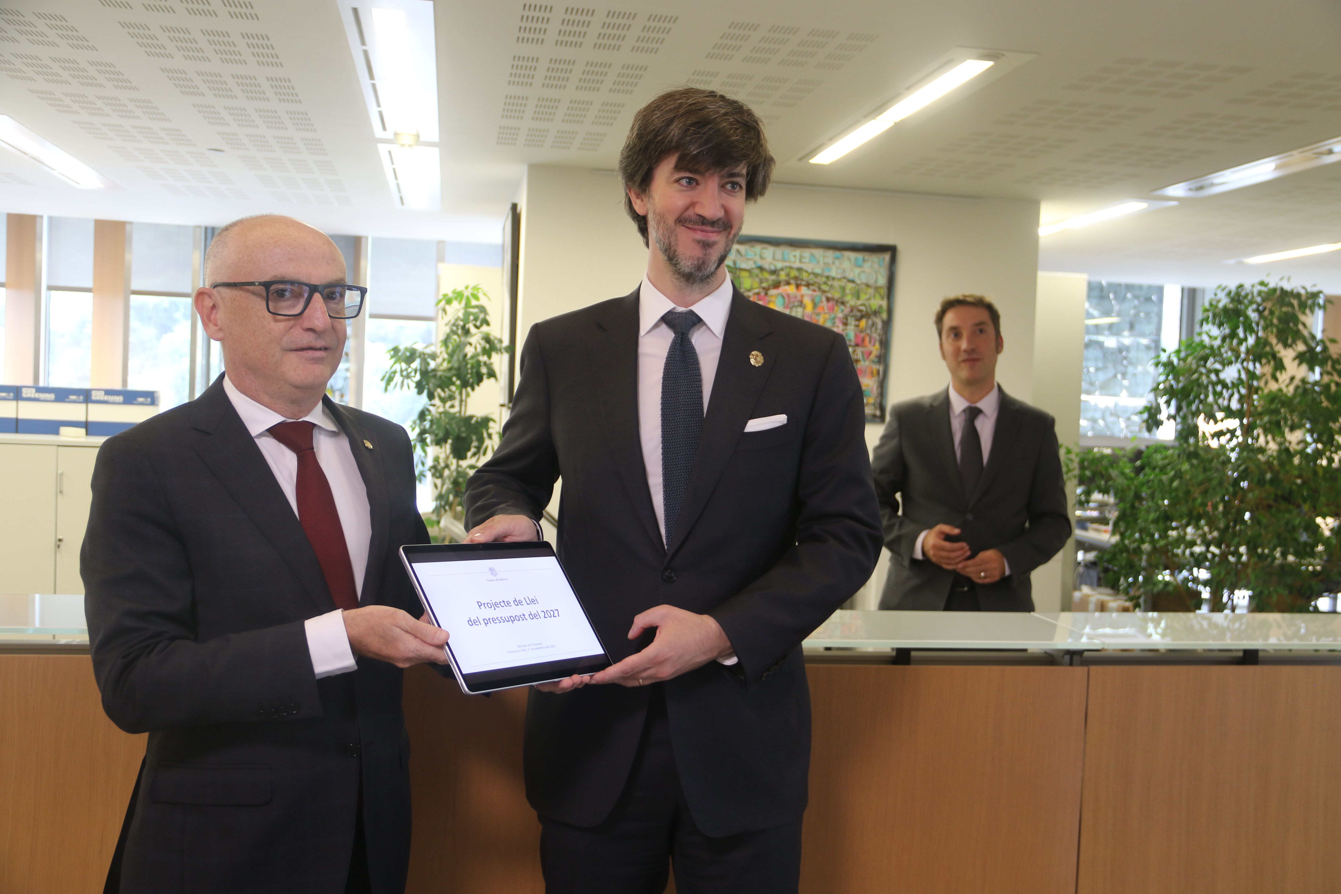 El ministre Ramon Lladós i el síndic, Carles Ensenyat, simbolitzant l'entrada del pressupost.