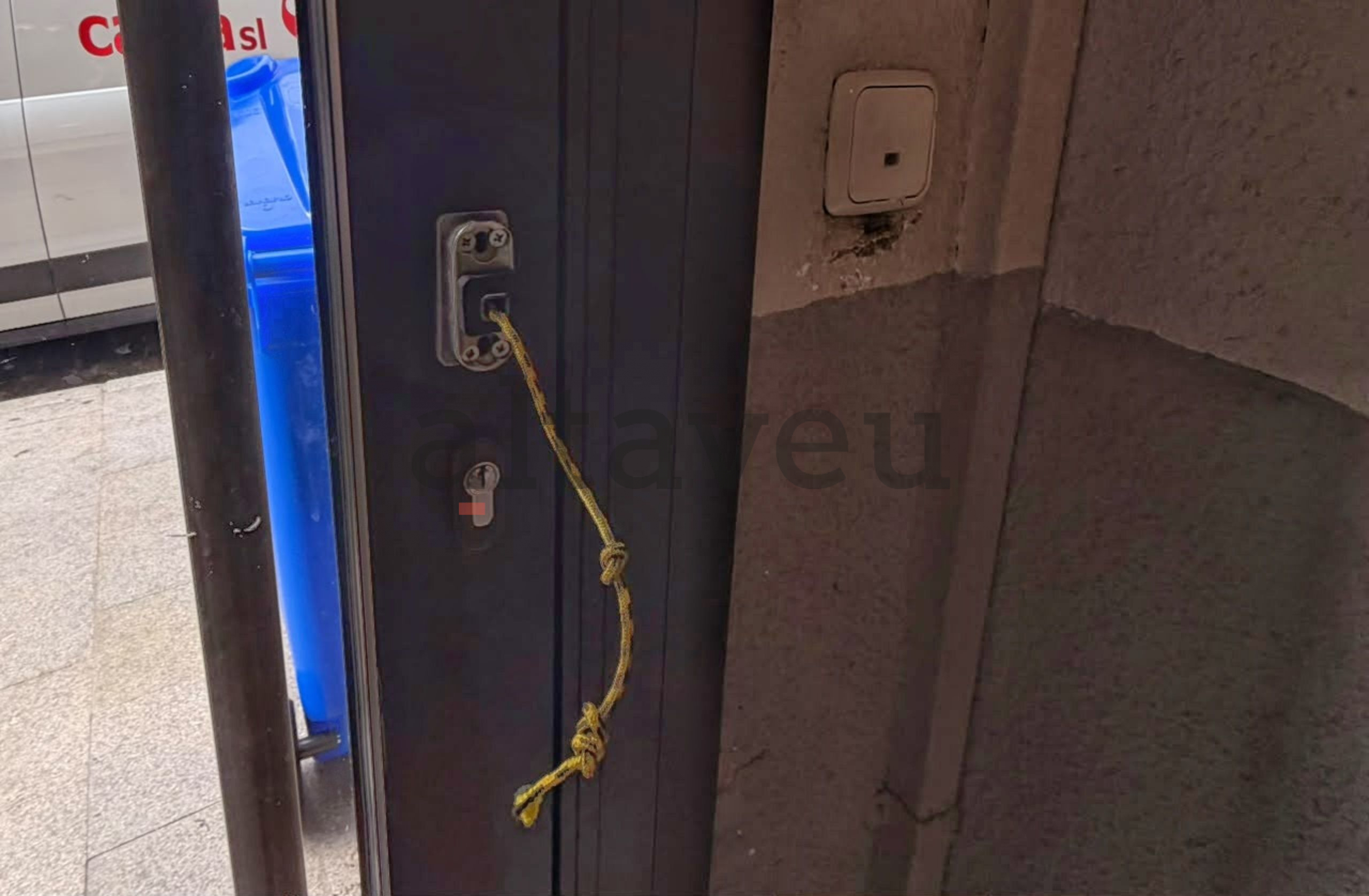 Una corda serveix de tirador de la porta. Una corda serveix de tirador de la porta.
