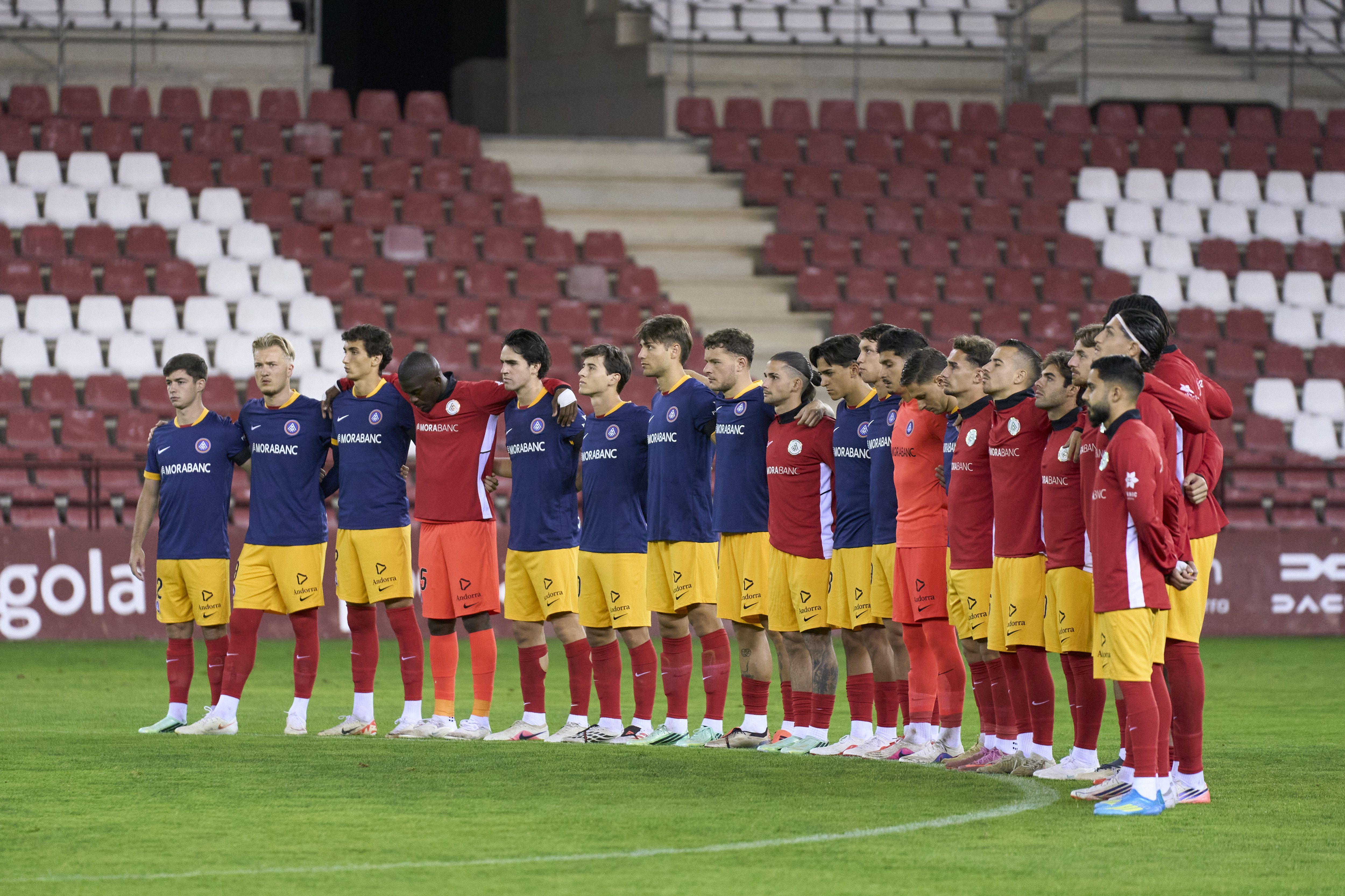 Titulars i suplents de l'Andorra durant el minut de silenci per les víctimes de l'accident a Toledo. | FC ANDORRA La portaveu del Sindicat, Rebeca Bonache.