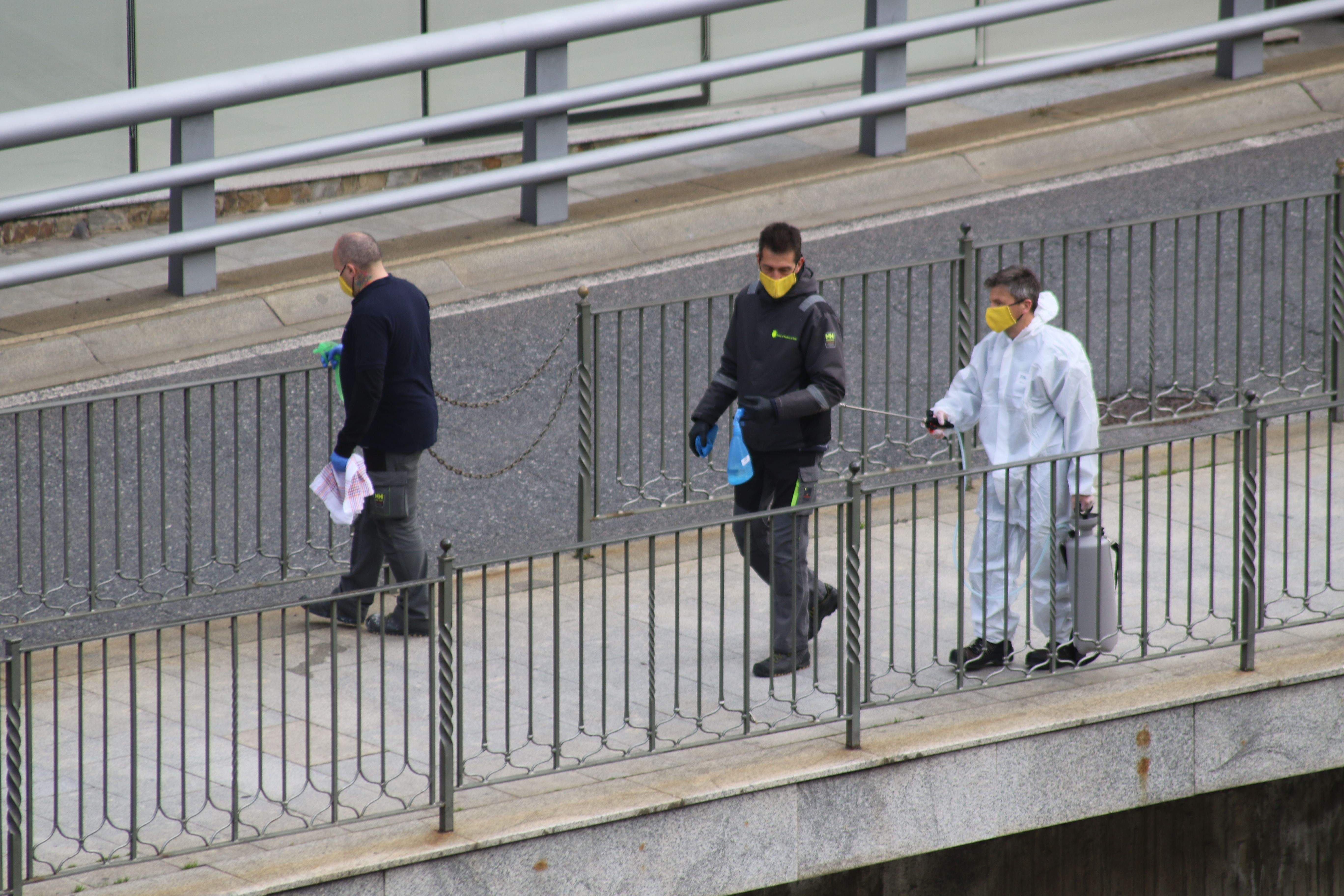 Tres operaris del comú d'Andorra la Vella netejant la via pública a prop del Pont de París.