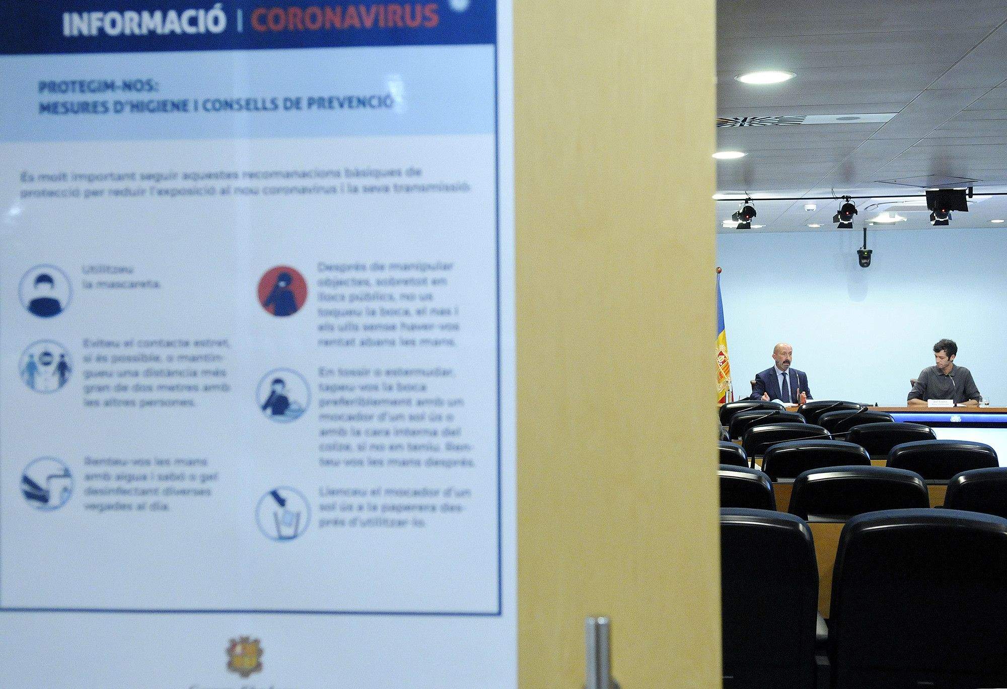 Compareixença de Joan Martínez Benazet i Joel López amb un cartell de mesures de protecció en primer terme.