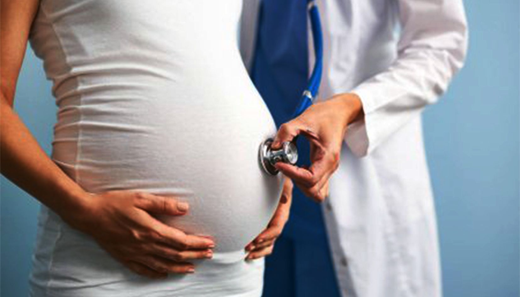 Una doctora fa un reconeixement a una dona embarassada.