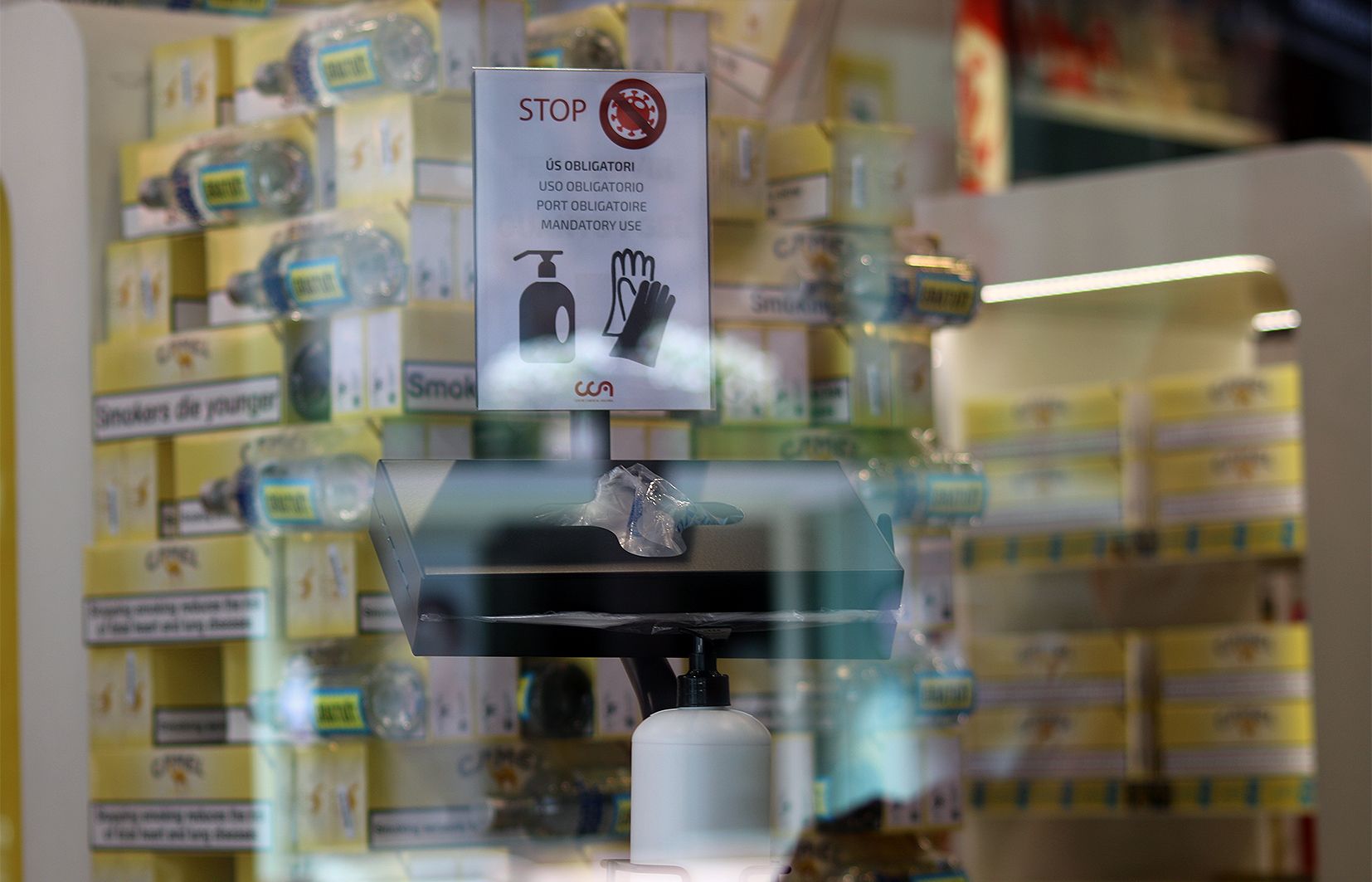 Un rètol a l'entrada d'un establiment que alerta que cal higienitzar-se bé i dur guants.