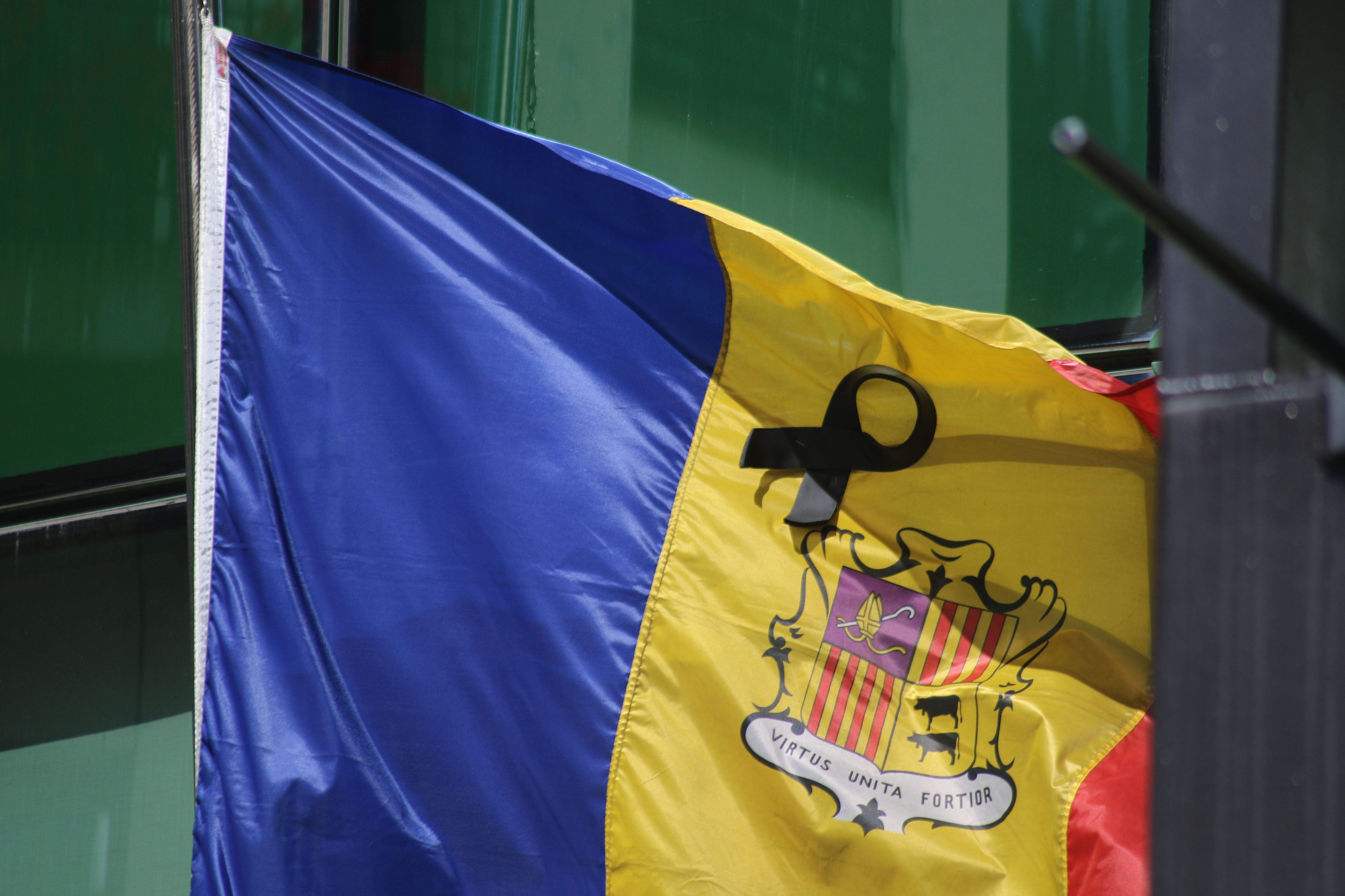 Bandera a mig pal i amb un crespó negre a la façana d'una institució financera.