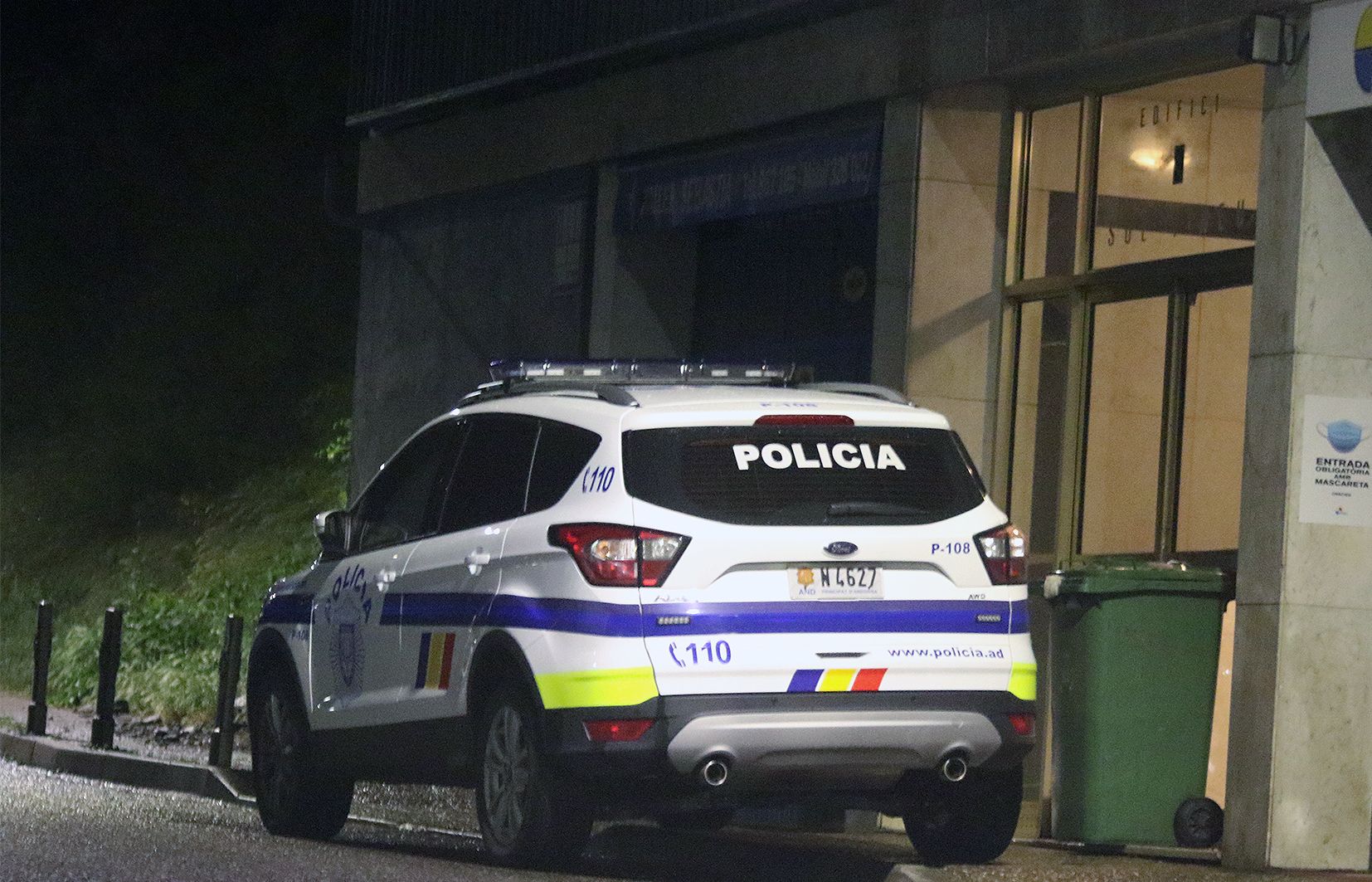 Un vehicle policial davant l'entrada de l'edifici.