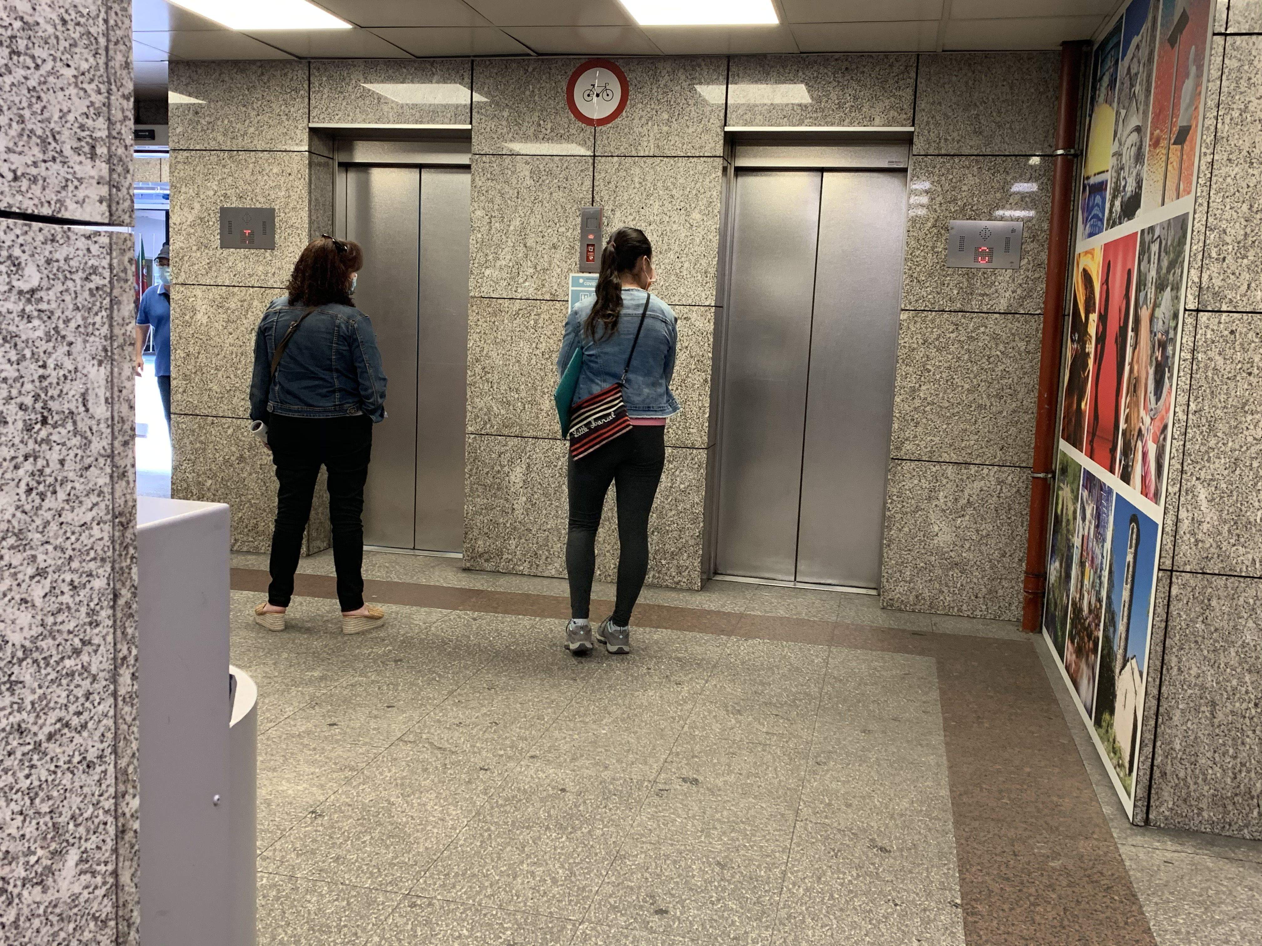 Dues ciutadanes esperant l'ascensor que puja a la Plaça del Poble.