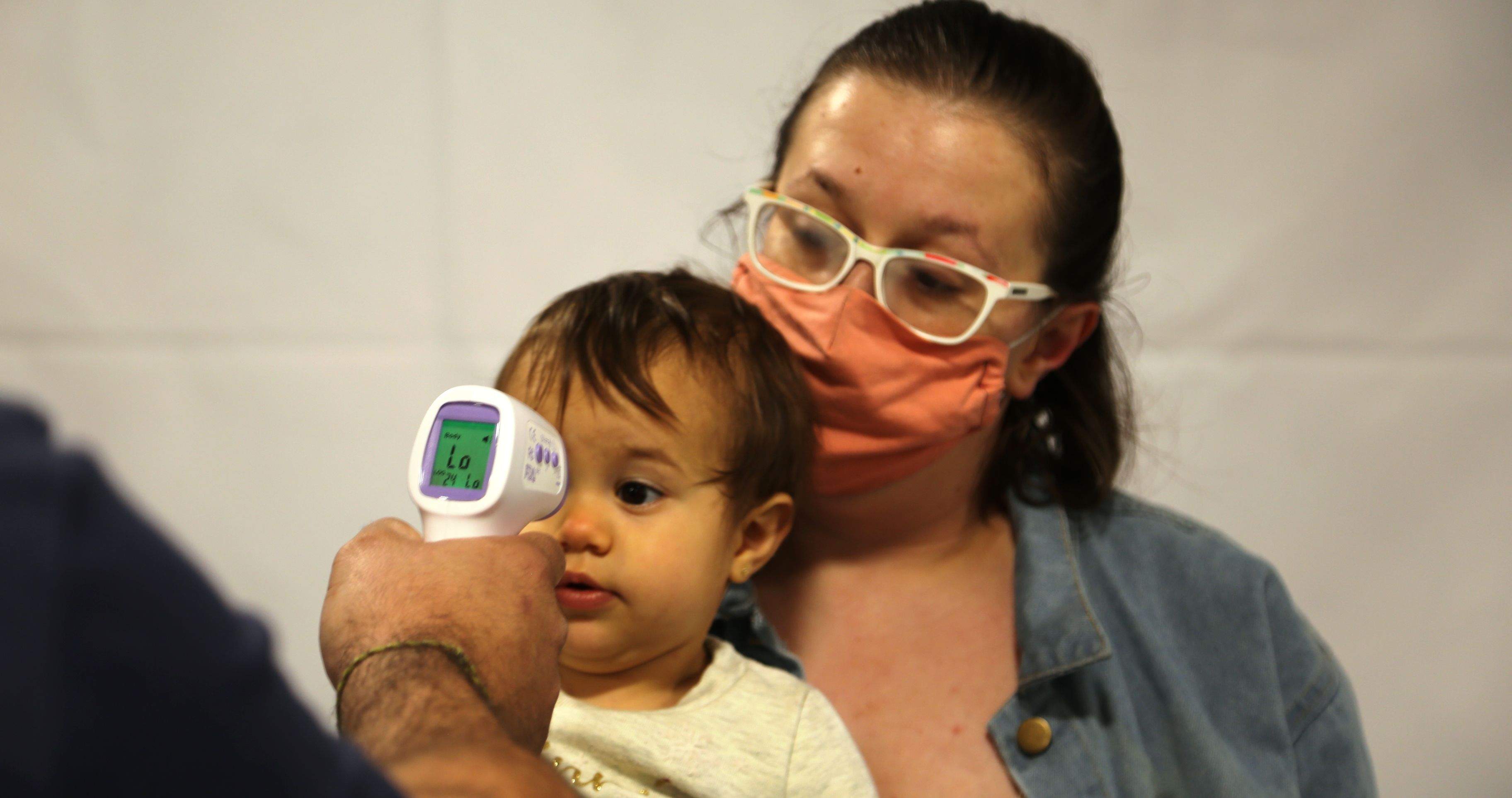 El director de l'escola bressol de Sant Julià pren la temperatura a un infant.