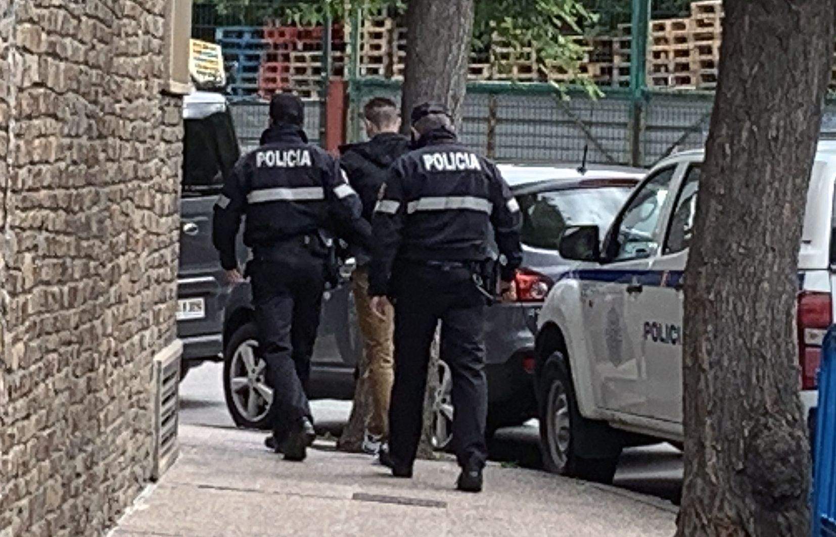 Dos agents de policia condueixen el jove cap a la sala d'actes de Prada Casadet on se celebrava el judici.