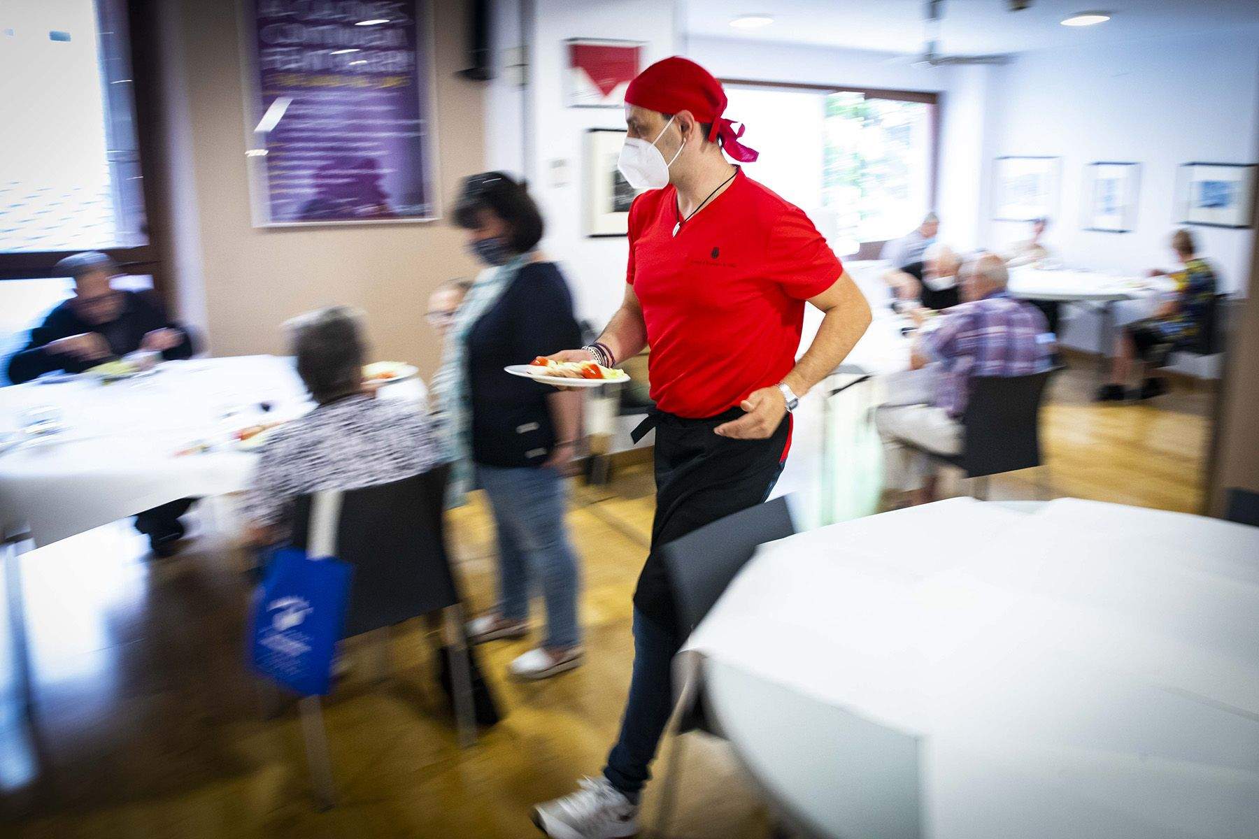 Un cambrer es disposa a servir un plat.