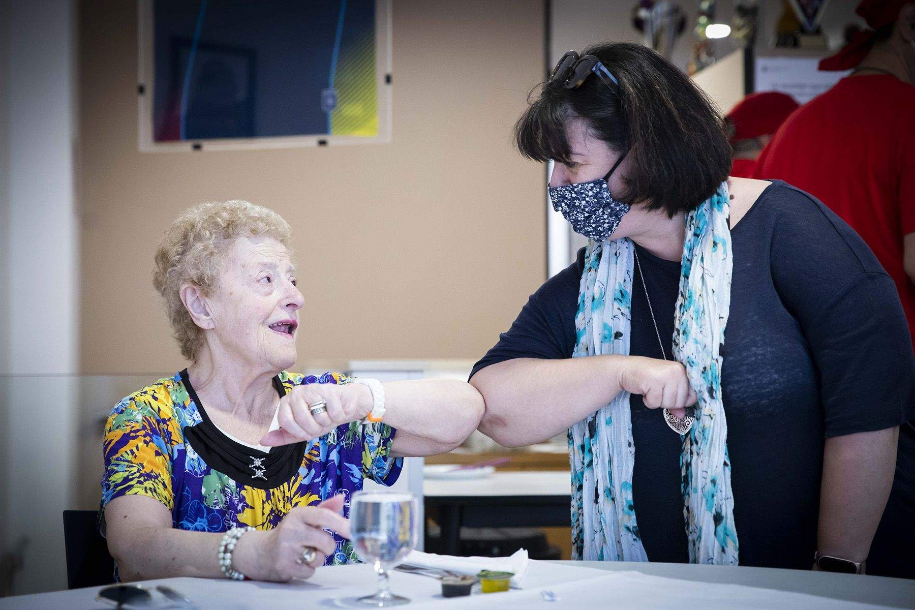 Una padrina saluda l'encarregada del Casal.