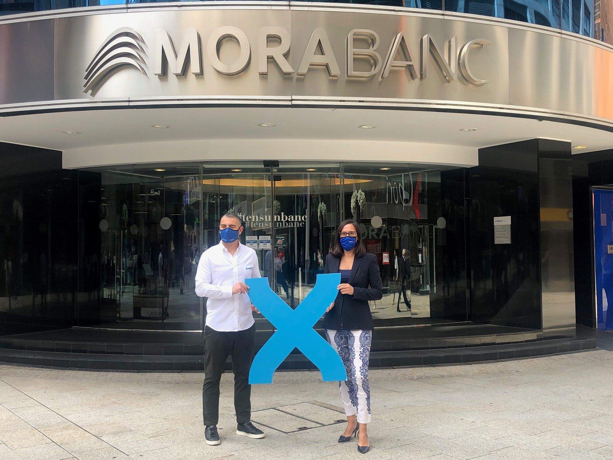 David Ledesma i Marta Riera escenifiquen l'acord davant la seu central de MoraBanc.